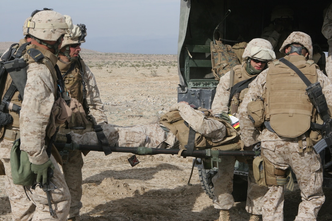 The Marines and sailors of 2nd platoon?s aid and litter team evacuate a casualty into the back of a vehicle.