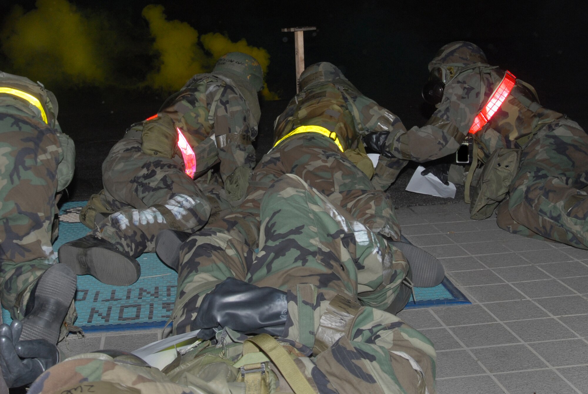 Airmen assigned to the 18th Munitions Squadron  precision guided munitions shop, low-crawl their way out of Bldg. 47801 to a safe location after a conventional missile attack during Local Operational Readiness Exercise Beverly High 08-2 at Kadena Air Base, Japan, Dec. 7, 2007. The LORE scenarios provide realistic training and improve the combat readiness of Kadena Airmen.
(U.S. Air Force photo illustration/Staff Sgt. Chrissy FitzGerald) 