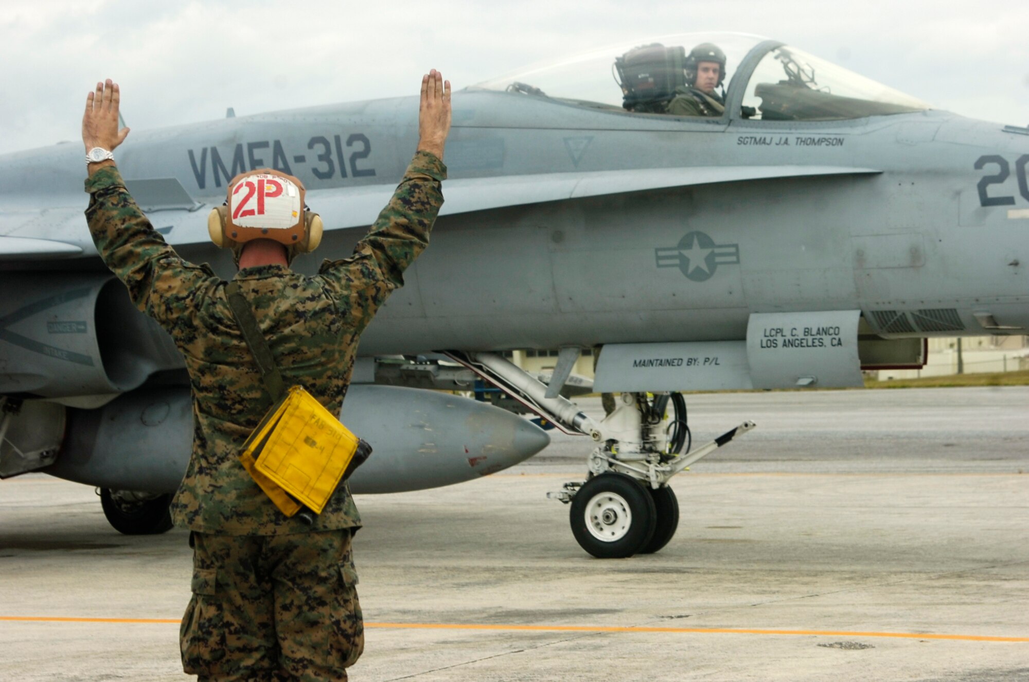 Cpl. Sterling L. Robertson, a powerliner for Marine Fighter Attack Squadron 212, instructs the pilot, Capt. Olgierd J. Weiss, with take off commands at Kadena Air Base, Japan, Dec. 4, 2007.  A powerliners job is to instruct on start up and launch out the pilot. Powerliners are the "eyes on the ground" for the pilot. 
(U.S. Marine Corps photo/Lance Cpl. Jacqueline Diaz)