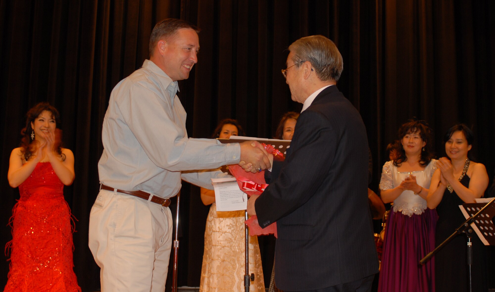 OSAN AIR BASE, Republic of Korea --  Col. Jon A. Norman, the commander of the 51st Fighter Wing, thanks Dr. Cho, Ki Hung, the president of Pyeongtaek University, for putting together the Pyeongtaek University Concert on Dec. 5. This is the third year that professors and students from the university have entertained Osan with music and dance. (U.S. Air Force photo by Senior Master Sgt. Marvin Krause)