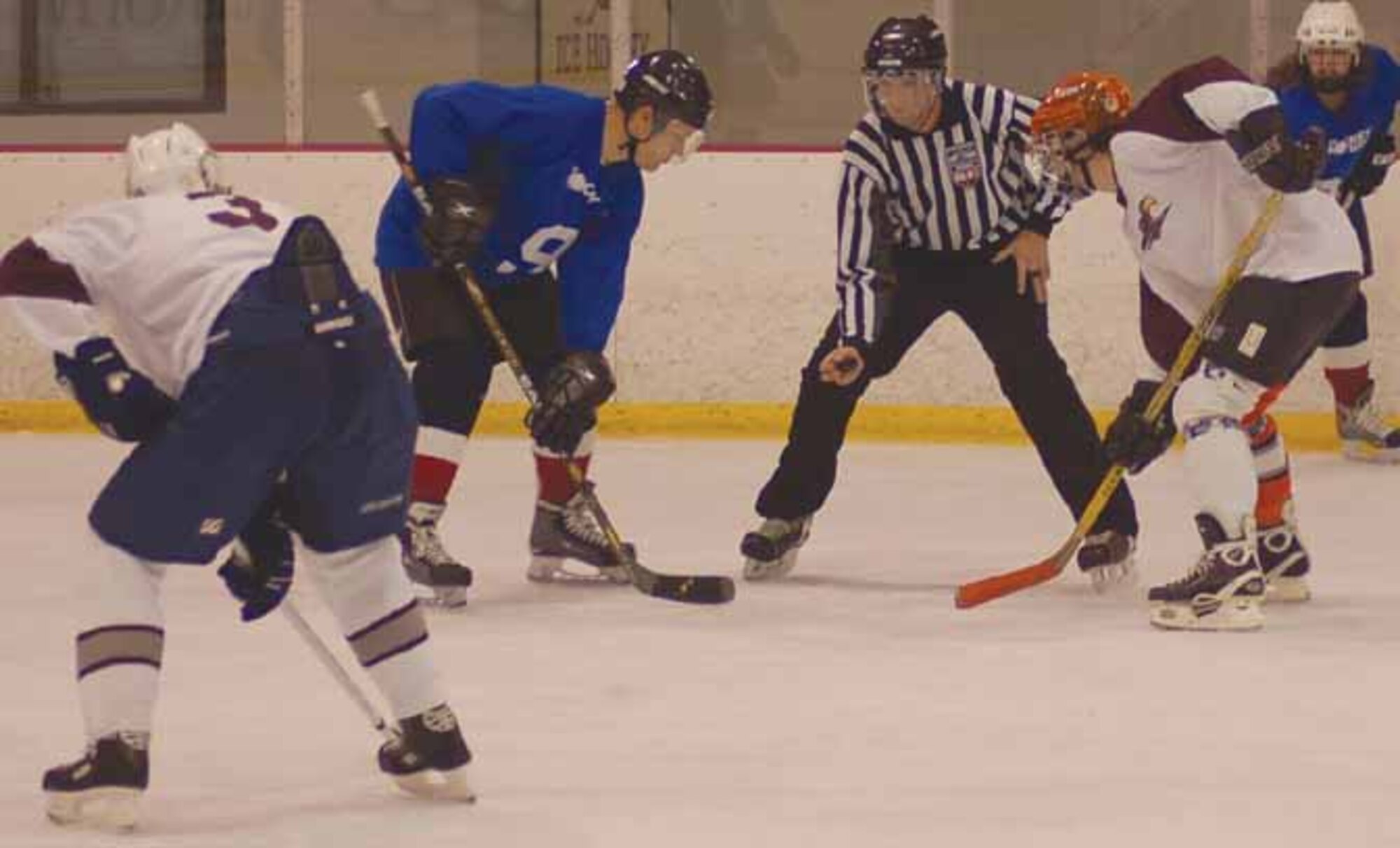As his teammate George Ambeland (3) waits, Tinker Hawks 2 center Clark McClay takes the face off during the second period of a game against the Blues. A four-goal third period sealed the Blues 6-3 victory Dec. 2 at the Blazers Ice Centre.  (Air Force photo by John E. Banks)