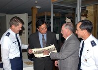 Fernando Cortez, curator of the History and Traditions Museum at Lackland Air Force Base, Texas, accepts a photo from Eugene Clary on Nov. 16, while his son, Maj. Gen. David Clary, Air Combat Command vice commander, and Col. Eric Wilbur, 37th Training Wing vice commander, look on.  Mr. Clary's donation is a rare vintage photograph of himself in one of the first basic military training classes held at Lackland, dating back to 1947. (USAF photo by Alan Boedeker)
