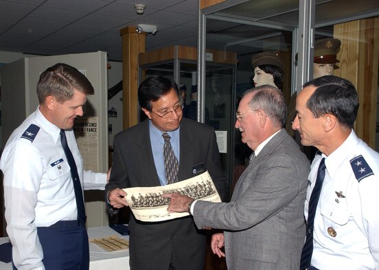 Fernando Cortez, curator of the History and Traditions Museum at Lackland Air Force Base, Texas, accepts a photo from Eugene Clary on Nov. 16, while his son, Maj. Gen. David Clary, Air Combat Command vice commander, and Col. Eric Wilbur, 37th Training Wing vice commander, look on.  Mr. Clary's donation is a rare vintage photograph of himself in one of the first basic military training classes held at Lackland, dating back to 1947. (USAF photo by Alan Boedeker)