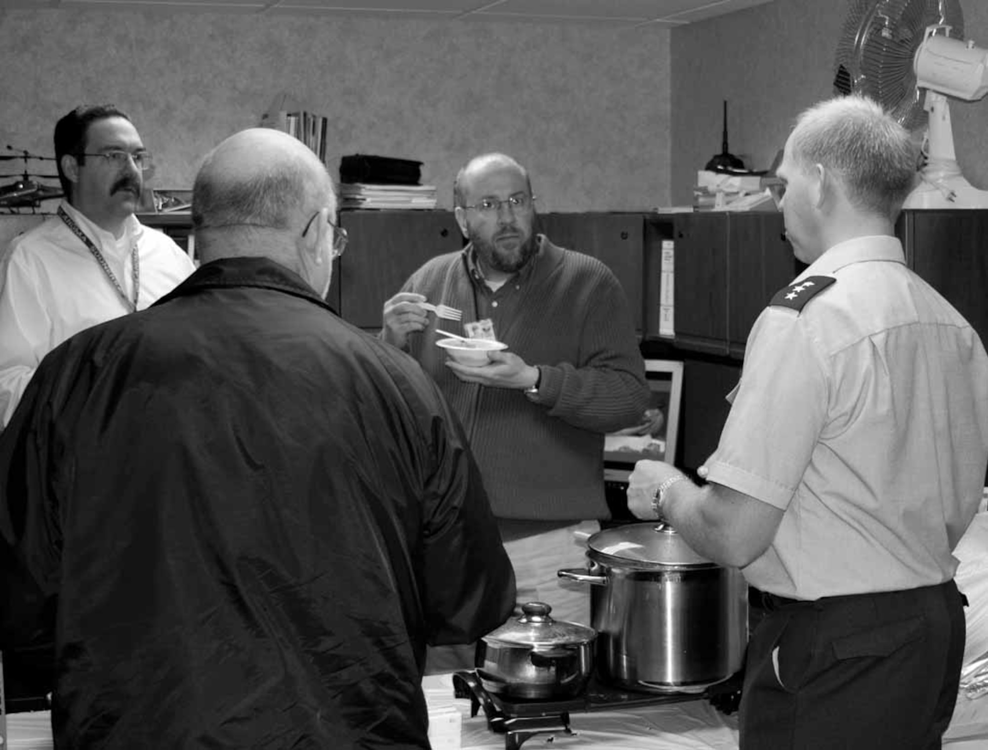 Harald Ekkjestol, right, talks with, from left, Loren Lutz, Roy Kline and R.J. Boyce, Nov. 27 during the second European Participating Air Force social event at Tinker, which was organized by country representatives of Belgium, Norway and The Netherlands.  EPAF is a F16/F100 partnership created between the United States Air Force and the air forces from Belgium, Denmark, Norway and The Netherlands in 1975.  Portugal joined the team in 2000; however, Denmark and Portugal don't have representatives at Tinker.  To celebrate the collaboration with the 540th Combat Sustainment Squadron and to share culinary culture, the organizers exchanged their computers for pans and cookers and prepared some traditional dishes from their home countries.  Belgian chocolates and waffles, Dutch cookies and candies, Norwegian chocolates and rice cream were also offered.  Organizers said the event was a success with many people who tasted the different foods.  (Photo by Patrick Guns)