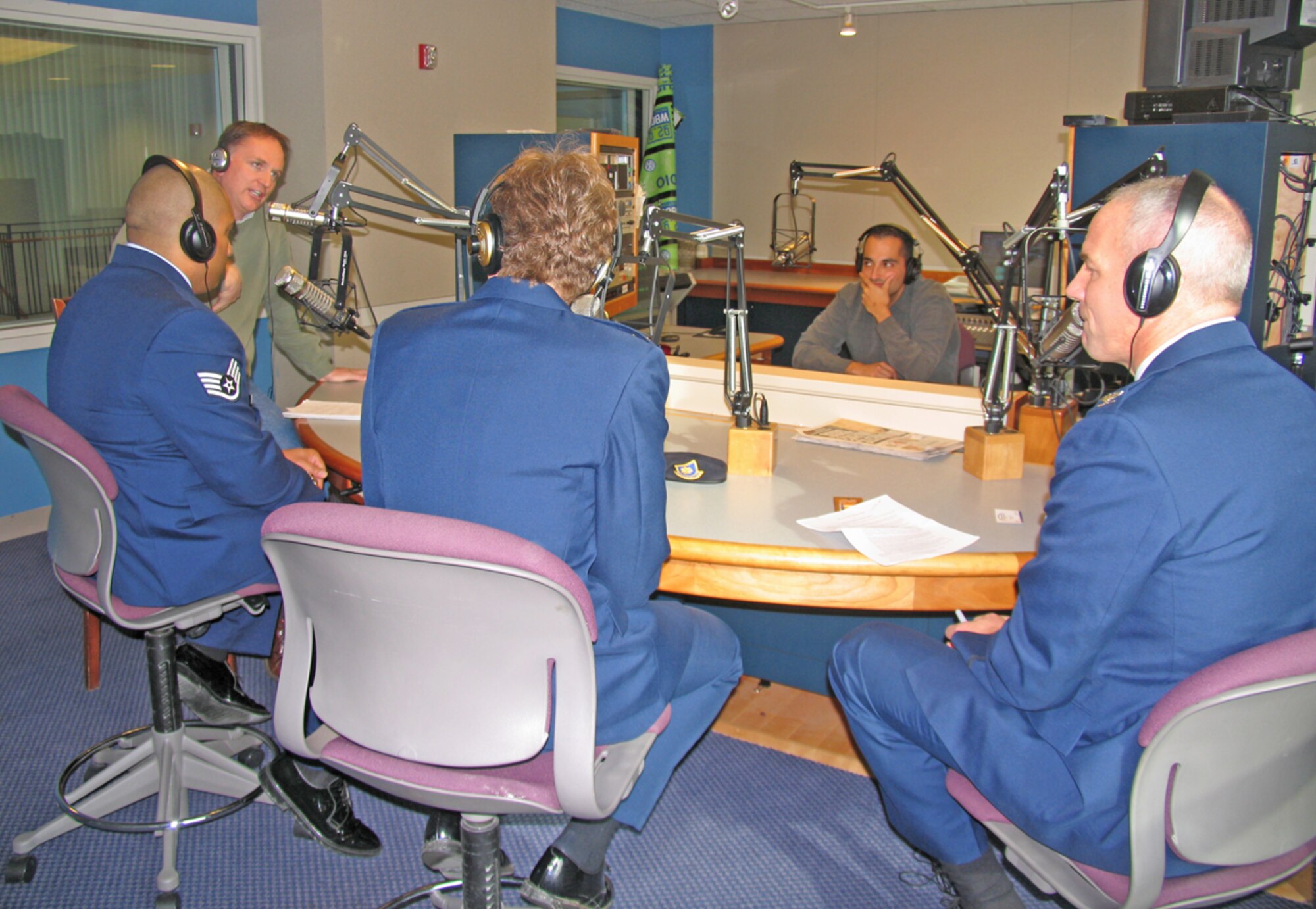 HANSCOM AFB, Mass. – FM 96.9 radio talk show host, Michael Graham, (left) interviews Staff Sgt. Patrick Raass, 653rd Electronic Systems Wing noncommissioned officer in charge, Maj. Tammy Mayer, 66th Security Forces Squadron commander, and Col. Tom Schluckebier, 66th Air Base Wing commander, about the deployments of Hanscom Airmen on Dec. 4. Sergeant Raass and Major Mayer recently returned from deployments and were honored during Hanscom’s Heroes’ Homecoming event on Dec. 5, which was emceed by Mr. Graham. (U.S. Air Force photo by 1st Lt. Lisa Spilinek)