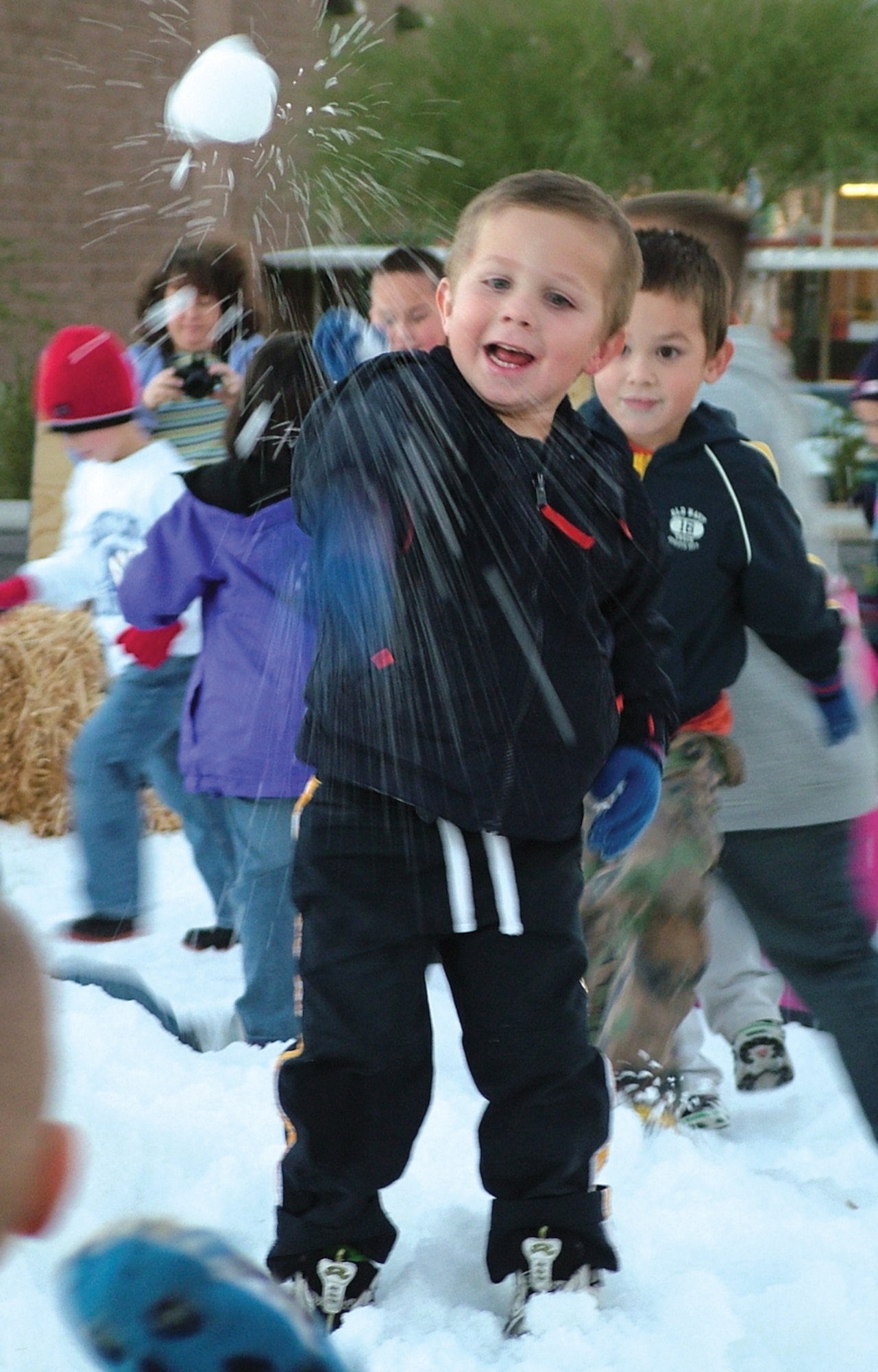 Nicholas, son of Melanie and Ronald Stamps, throws a snowball during snow play time at Davis-Monthan's base chapel parking lot area, during A Starry Snowy Southwest night holiday celebration Dec. 3. (Desert Lightning News photo by Shelly A. McGuire)