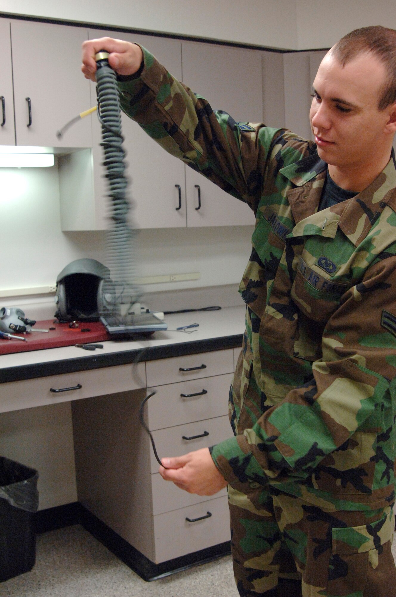 MCCONNELL AIR FORCE BASE, Kan. -- Airman 1st Class Cody Jaglowicz, 22nd Operations Support Squadron, Aircrew Flight Equipment technician, removes the communication cord from around the oxygen hose before cleaning a helmet.  Every 90 days the Aircrew Flight Equipment technicians have to inspect and clean all helmets.  The Aircrew Flight Equipment provides and maintains the survival equipment for the air crew personnel.  (Photo by Tech. Sgt. Chyrece Campbell)