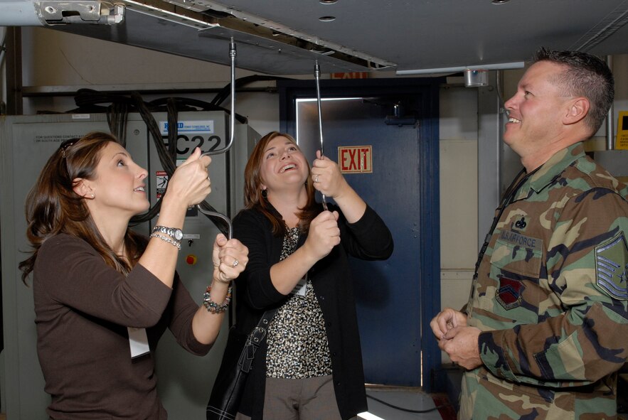 Master Sgt. Richard White, 56th Equipment Maintenance Squadron, observes Diane Traw and Roseanna Scheel assemble a plate onto the bottom of an F-16 wing. Both women participated in the 56th Maintenance Group immersion day Nov. 14. (photo by Staff Sgt. Steven Nabor)