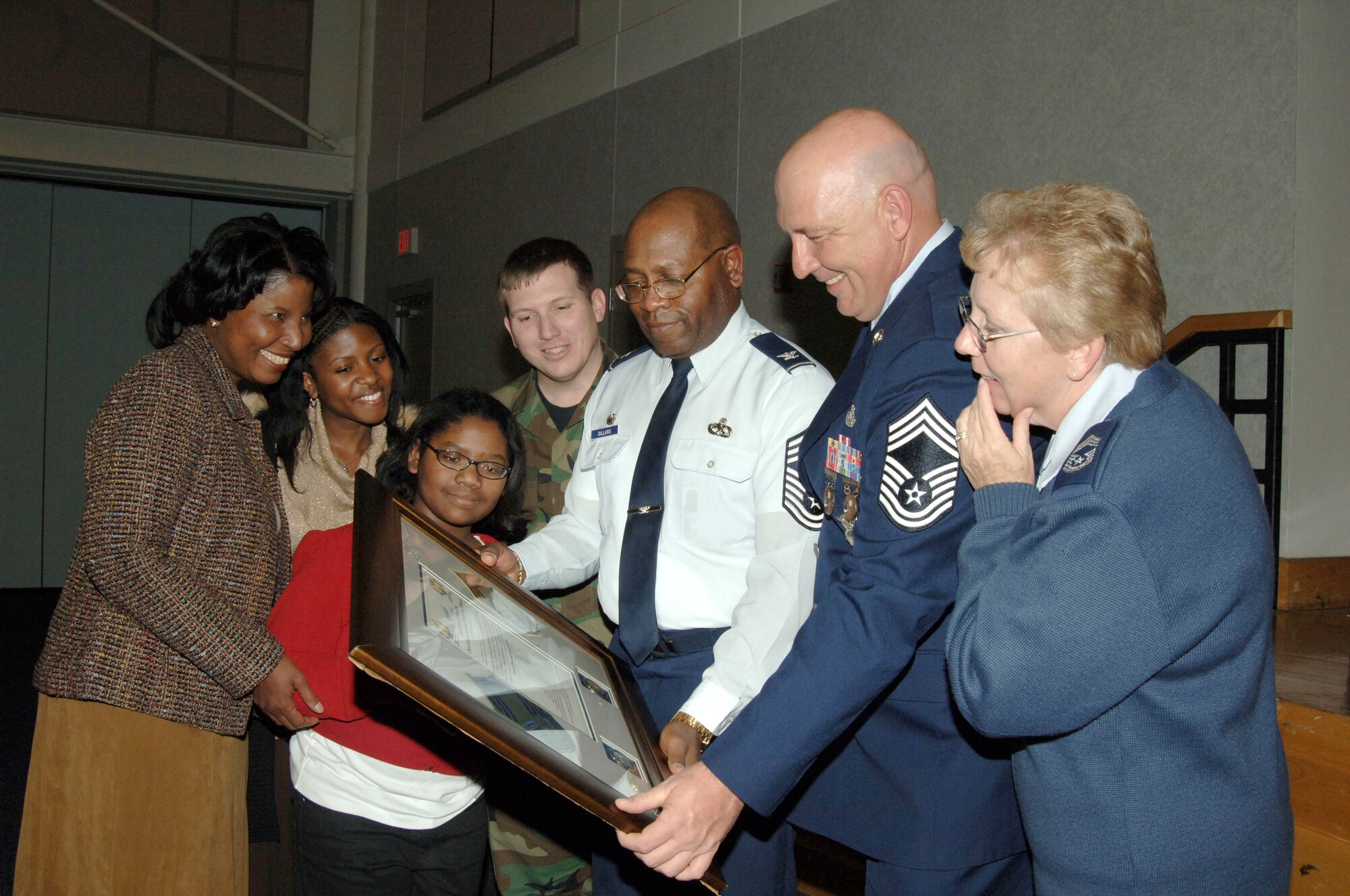 Colonel Michael Dillard, 22nd Maintenance Group commander and his family view a plaque that was presented to him by the Chief’s group and McConnell members for being inducted as an honorary enlisted chief master sergeant at a promotion ceremony Nov. 30. (photo by Tech. Sgt. Chyrece Campbell) 