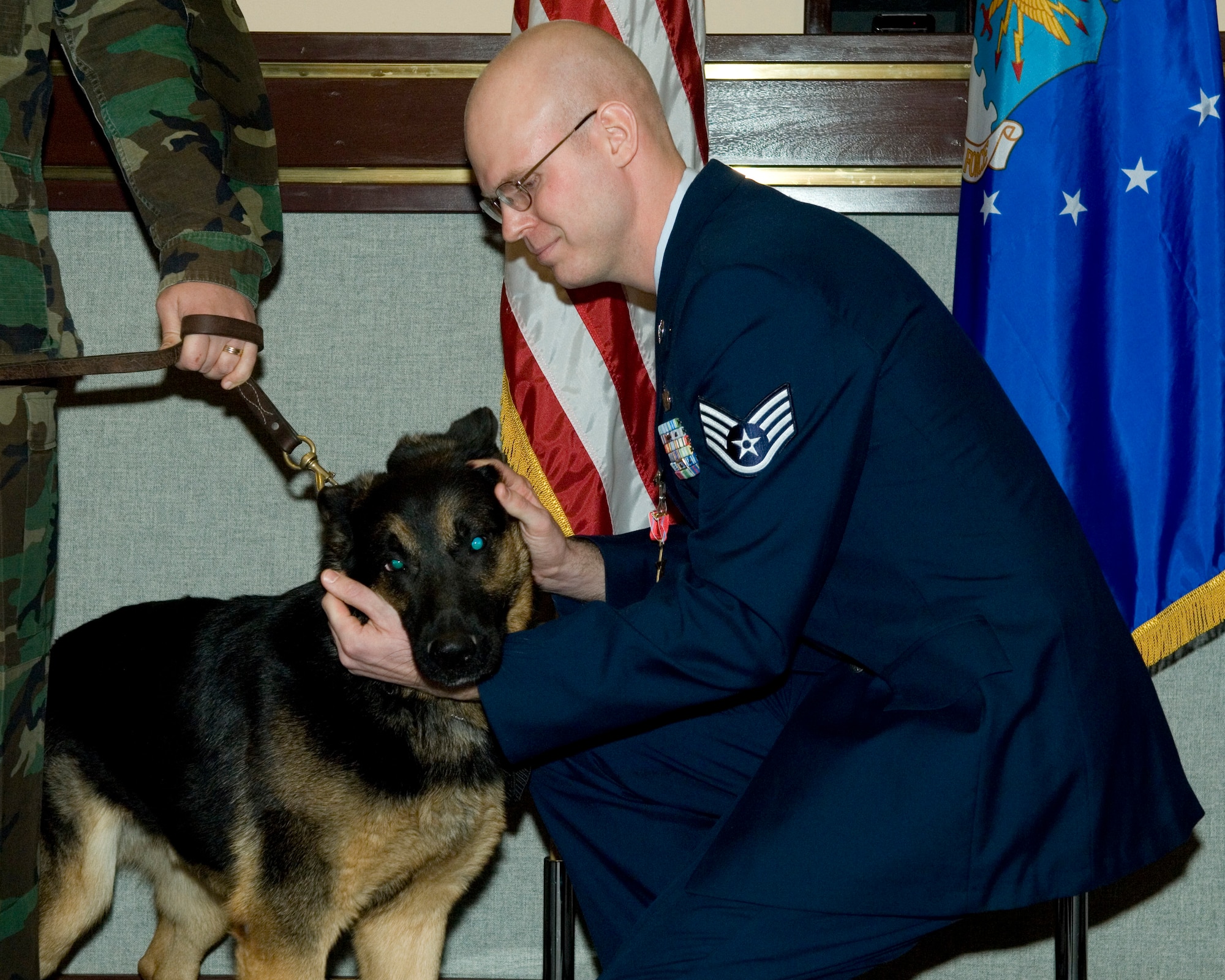 ELMENDORF AIR FORCE BASE, Alaska -- Staff Sgt. Christopher Barker, 3rd Security Forces Squadron K-9 handler, shows Jack, a military working dog, appreciation during a ceremony here Dec. 4. Sergeant Barker and MWD Jack received the Bronze Star for support they provided while deployed in support of Operation Iraqi Freedom. Sergeant Barker and Jack were sweeping for a weapons cache in an Iraqi field in June 2006, when they discovered 2,000 pounds of explosives buried in eight locations. The cache was set as a trap with an armed anti-personnel mine. Finding this mine possibly saved the life of a Soldier.
Throughout Sergeant Barker’s and Jack’s deployment, they conducted more than 350 hours of combat patrols, in which they located more than 3,000 pounds of explosives, 76 automatic weapons, and 16 cell phones used for IEDs. The Bronze Star is awarded for bravery, acts of merit, or meritorious service. When awarded for bravery, it is the fourth-highest combat award of the U.S. Armed Forces and the 9th highest military award (including both combat and noncombat awards) in the order of precedence of U.S. military decorations. (U.S. Air Force photo by Airman 1st Class Jonathan Steffen)

