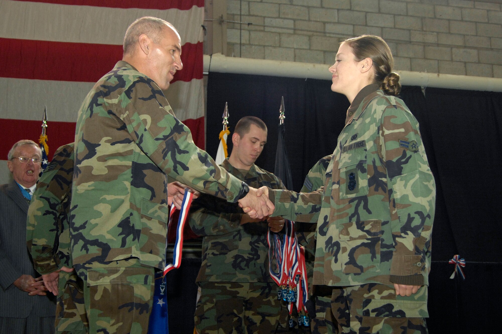 HANSCOM AFB, Mass. -- Airman 1st Class Jessica Brown, 66th Security Forces Squadron, is congratulated by Col. Tom Schluckebier, 66th Air Base Wing commander, during Hanscom’s Heroes’ Homecoming event Dec. 5. Airman Brown was recognized during the celebration with 41 other recently returned deployers. (U.S. Air Force photo by Mark Wyatt)
