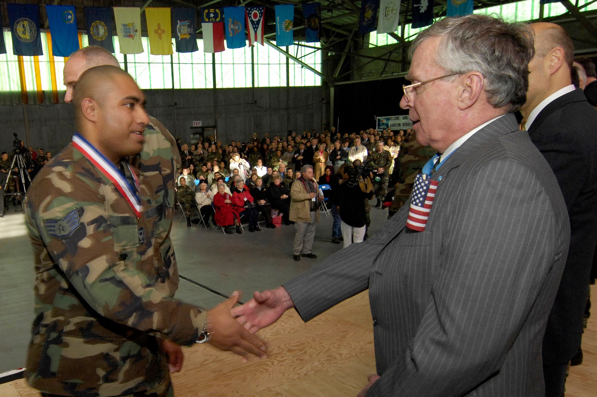 HANSCOM AFB, Mass. -- Staff Sgt. Patrick Raass, 653rd Electronic Systems Wing, shakes hands with Massachusetts Secretary of Veterans' Services Thomas Kelley, who is a recipient of the Medal of Honor and the Purple Heart, during Hanscom’s Heroes’ Homecoming celebration. The event, which honored Airmen assigned to Hanscom who had recently returned from deployments, was widely attended by base personnel and families as well as local community supporters. (U.S. Air Force photo by Mark Wyatt)