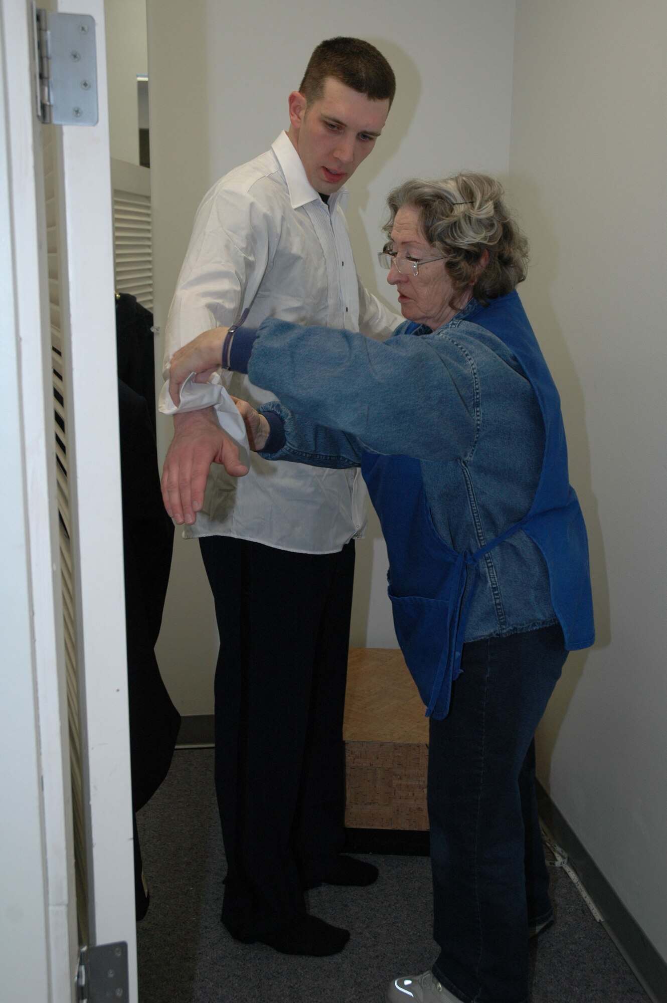 Irene Harris, head seamstress at the AAFES cleaners, sizes up 1st Lt. Justin Brockhoff, 341st Space Wing Public Affairs, in his mess dress. (U.S. Air Force photo/Valerie Mullett)