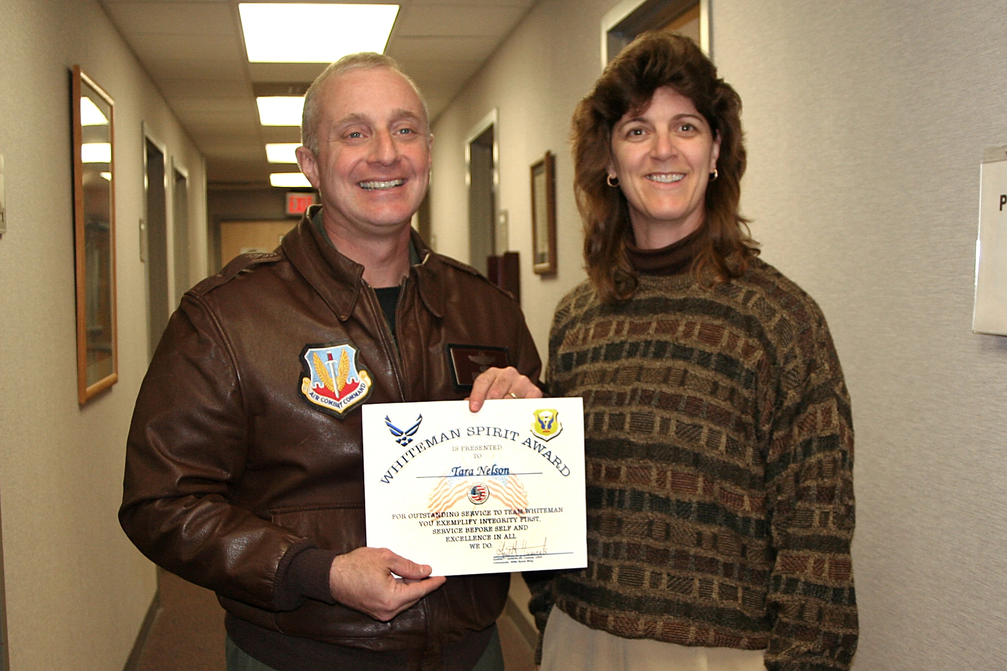 Physician Assistant Tara Nelson, 509th Medical Group received the Whiteman Spirit Award from Col.  Garrett Harencak, 509th Bomb Wing Commander, Dec. 3.  ( U.S. Air Force Photo by/ 1st Lt. Candace Cutrufo)