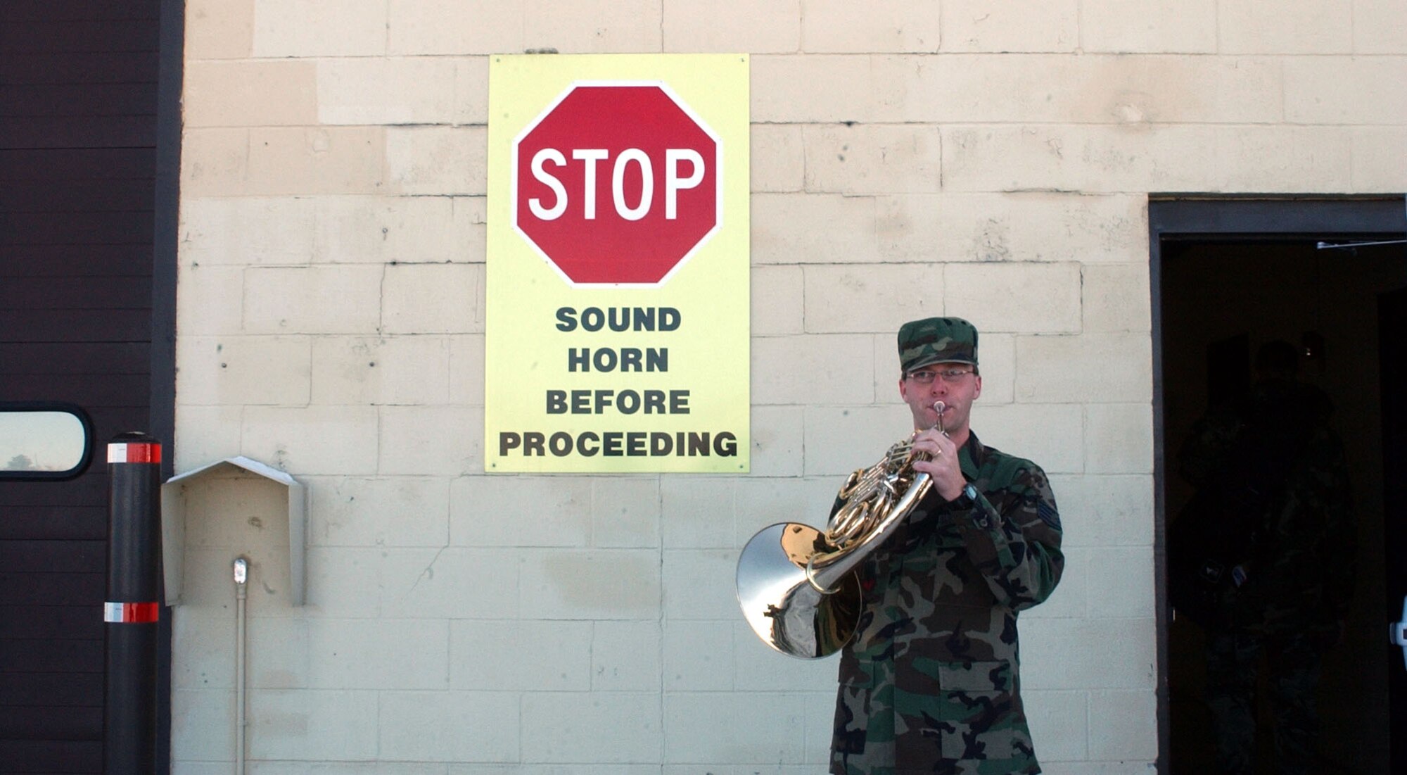 Staff Sgt. Ryan Heseltine makes light of a sign posted at building 3081 before entering with the rest of the Heartland of America Band when they were at Malmstrom to perform holiday music for the various organizations Nov. 27 and 28. (U.S. Air Force photo/2nd Lt. Korry Leverett)