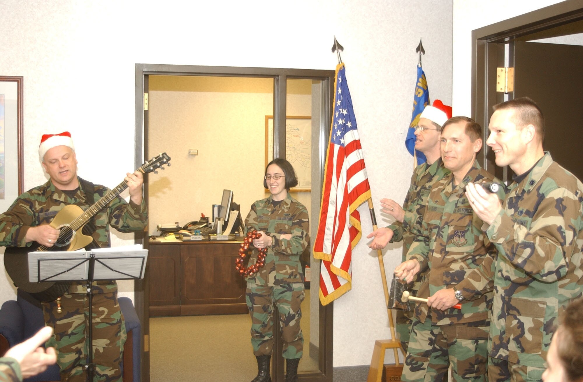 Tech. Sgt. Ken Maxwell, guitarist for the Heartland of America Band from Offutt Air Force Base, Neb., gets the 341st Mission Support Group leadership in the holiday spirit during their visit to Malmstrom Nov. 27 and 28. Pictured from left to right areExecutive Officer 1st Lt. Abigail Ono; band member Staff Sgt. Ryan Hesteline; 341st MSG Commander Col. Roderick Davis; and 341st MSG Deputy Commander Lt. Col. Mark Evans. (U.S. Air Force photo/2nd Lt. Korry Leverett)