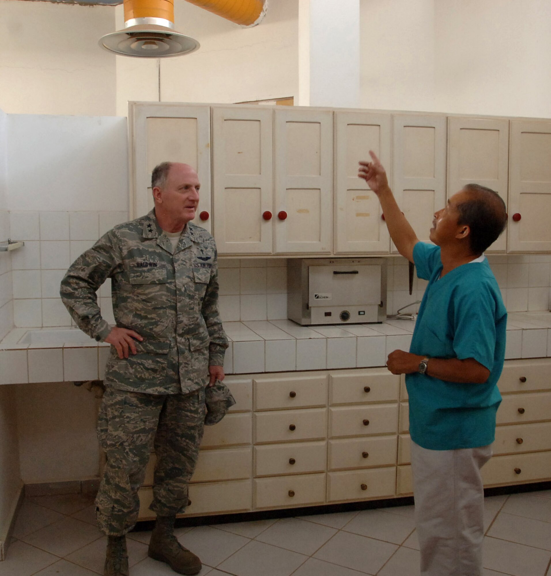Chaplain (Maj. Gen.) Charles C. Baldwin listens to Cornelio Aba, Djibouti Adventist Health Center dentist, as he talks about some of the upgrades that have been made to the facility Dec. 4 in Djibouti City, Djibouti. Chaplain Baldwin, Air Force chief of chaplains, delivered medical supplies that will help Mr. Aba as he provides dental care for the people of Djibouti. (U.S. Navy photo/Petty Officer 1st Class Mary Popejoy)