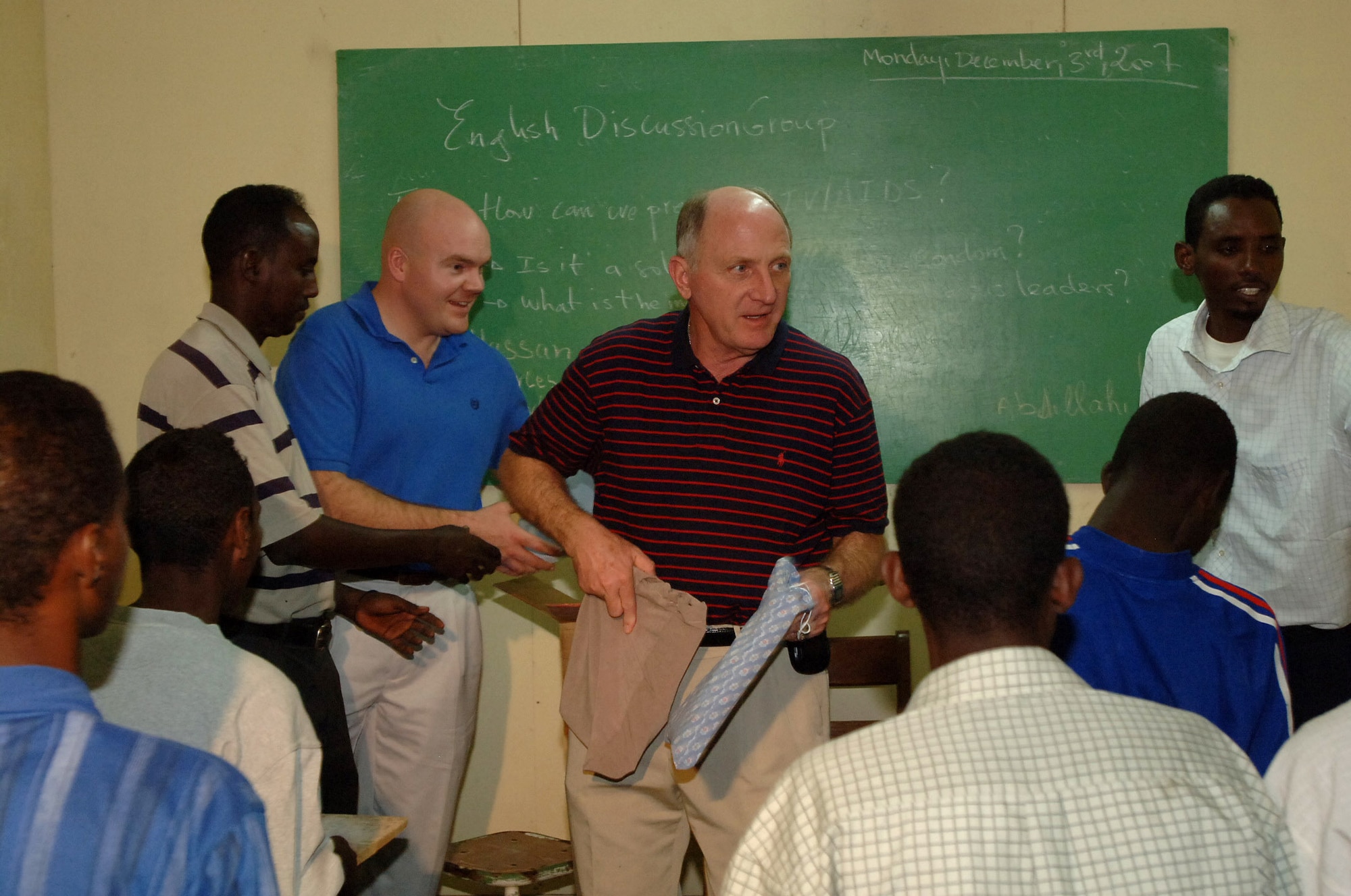 Chaplain (Maj. Gen.) Charles C. Baldwin hands out school supplies to the students of Horsed Private School of English following an English Discussion Group Dec. 3 in Djibouti City, Djibouti. The school supplies were donated by the Combined Joint Task Force-Horn of Africa's Spouses Group. Chaplain Baldwin is the Air Force chief of chaplains.(U.S. Navy photo/Petty Officer 1st Class Mary Popejoy) 