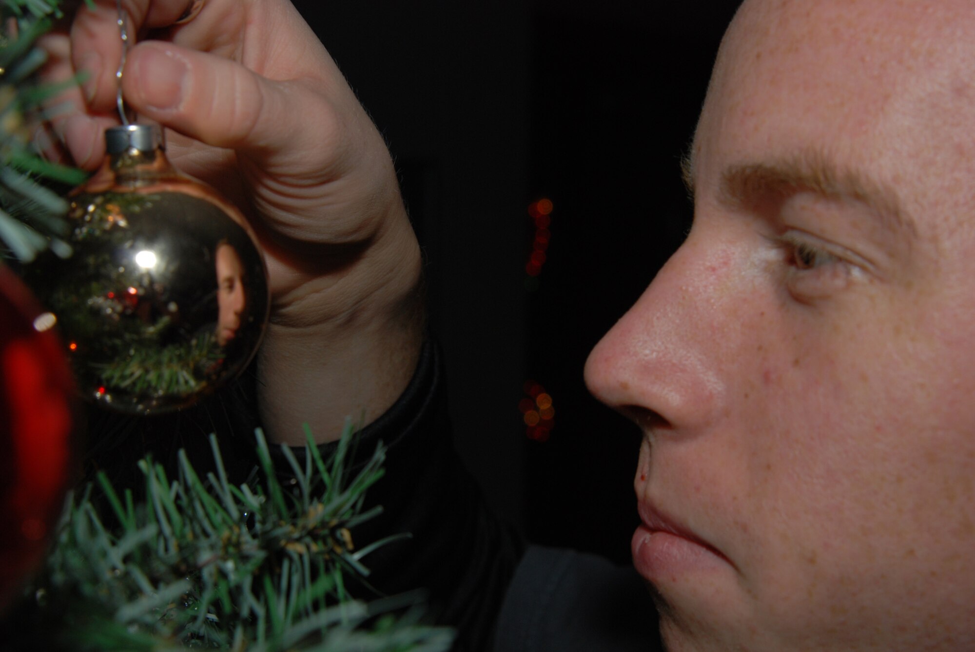 MCCONNELL AIR FORCE BASE, Kan. – Airman 1st Class Lucas Treat, 22nd Operations Group, puts final touches on a holiday tree in the Airman dorms Nov. 22 helping bring the spirit of the holiday season to dorm residence
(photo by Airman 1st Class Jessica Lockoski)
