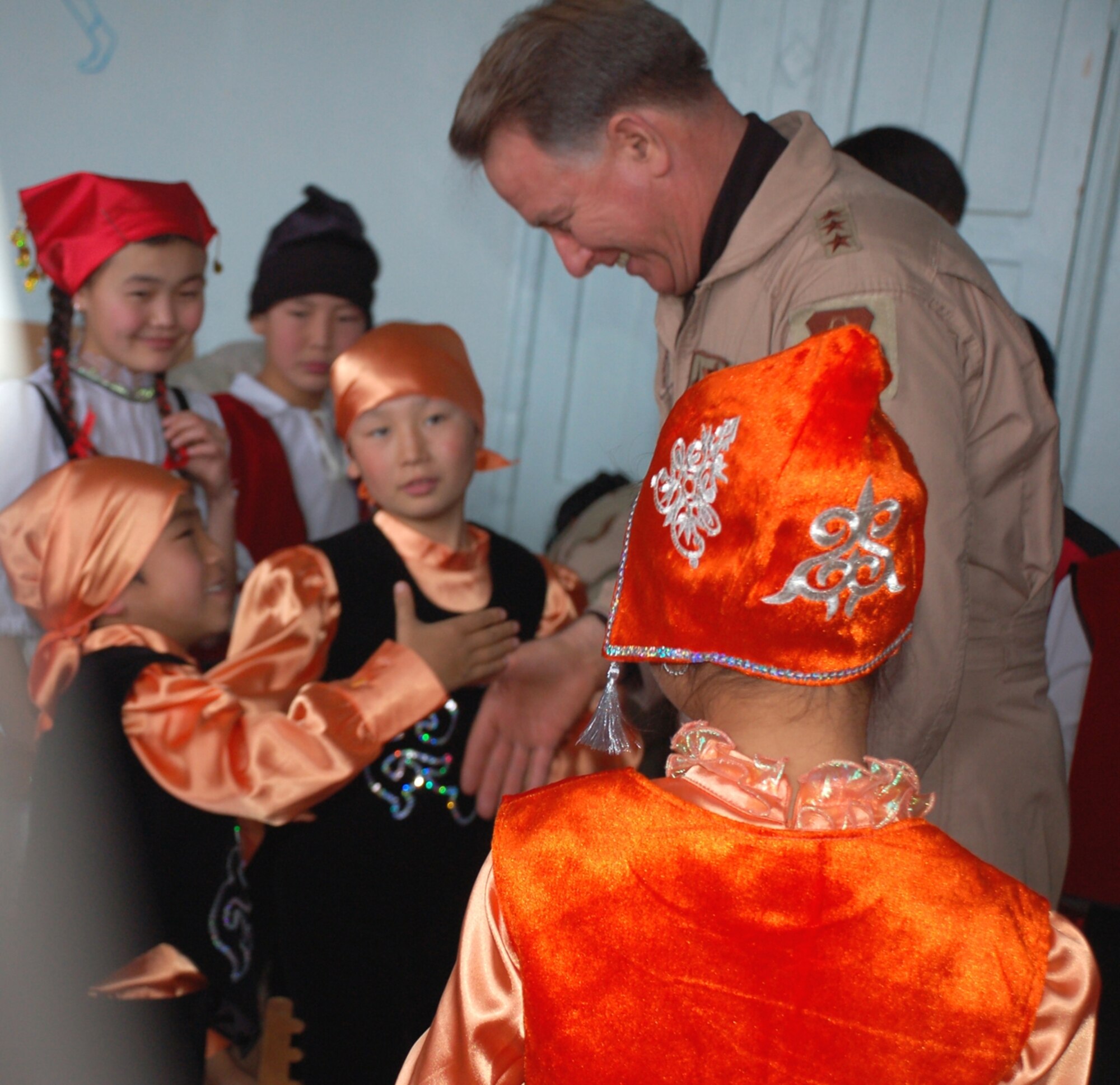Lt. Gen. John Bradley, commander of Air Force Reserve Command, greets children at the Bishkek Boarding School for the Deaf as he visited Dec. 4 to present donated gifts. (Air Force photo by Maj. Adriane Craig)