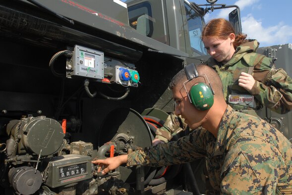 Lance Cpl. Joseph Rivera, MSWW 171, and Airman 1st Class Christina Flake, 18th Logistic Readiness Squadron, look at the fuel gauge of a R-11 fuel truck at Kadena Air Base, Japan, Dec. 6, as part of the maintenence process to ensure the fuel truck is operating correctly. Airmen from the 18th Wing joined with elements from the 1st Marine Aircraft Wing to conduct a joint operational readiness exercise here Dec. 3-7. (U.S. Air Force/Senior Airman Darnell T. Cannady)