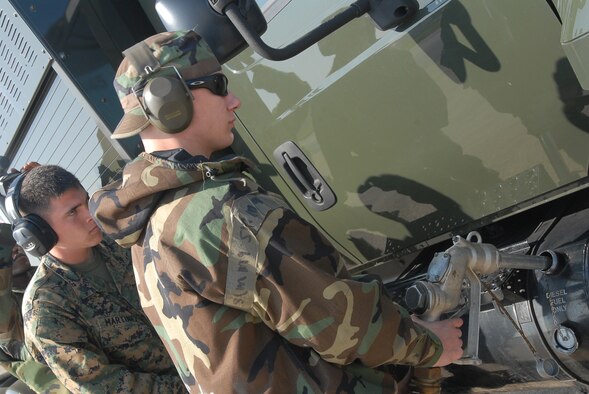 Airman 1st Class Luke Thompson, 18th Logistic Readiness Squadron, and Corporal Micah Martinez, MSWW 171, pump fuel into a R-11 fuel truck at Kadena Air Base, Japan, Dec. 6. Airmen from the 18th Wing joined with elements from the 1st Marine Aircraft Wing to conduct a joint operational readiness exercise here Dec. 3-7. (U.S. Air Force /Senior Airman Darnell T. Cannady)