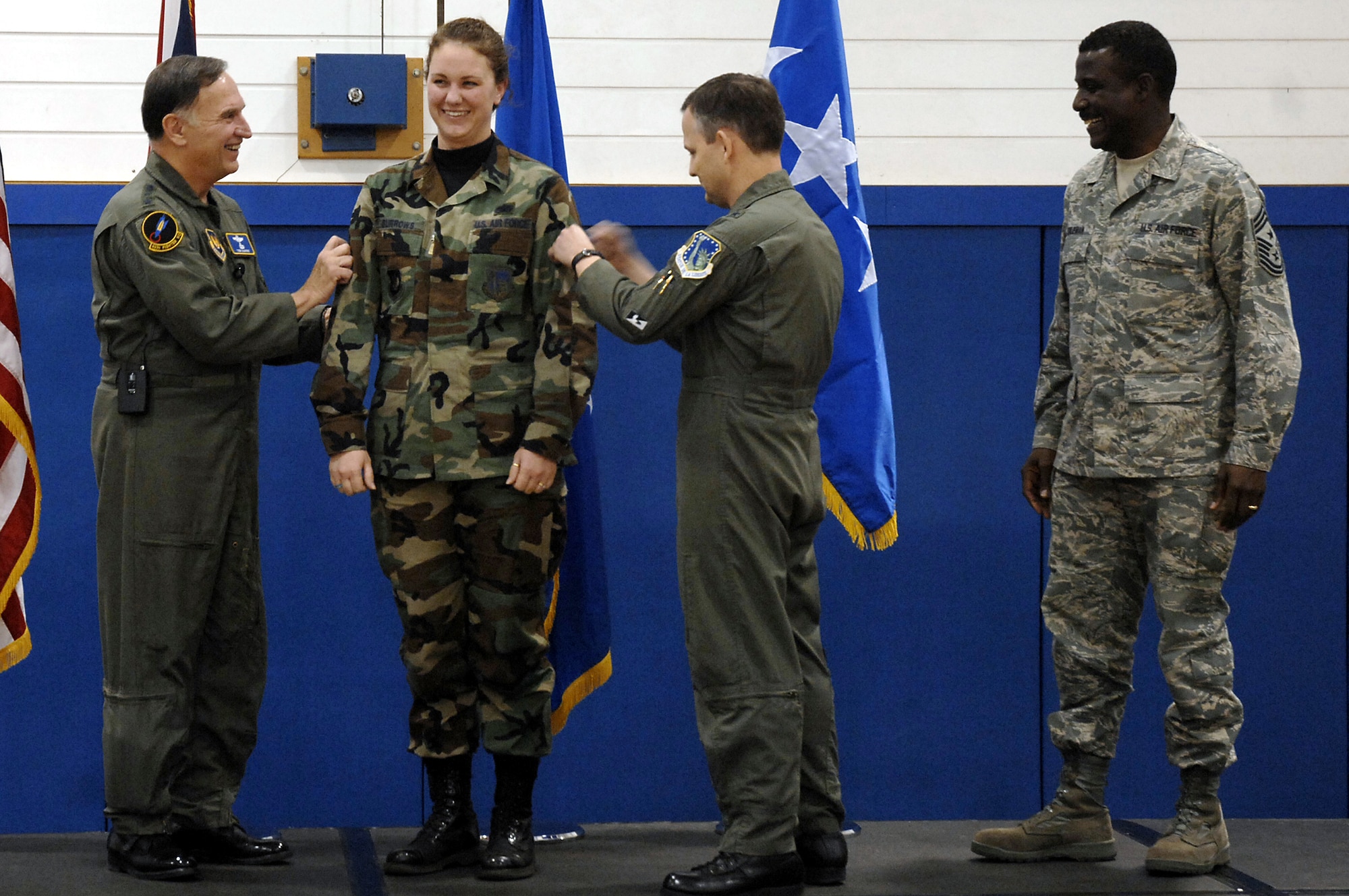 Gen. William T. Hobbins, U.S. Air Forces in Europe commander, and Brig. Gen. John Hesterman, 48th Fighter Wing commander, STEP promote Staff SSgt. Audrey Burrows, 48th Maintenance Group, to technical sergeant during an Airmen’s Call at RAF Lakenheath, England Dec. 3 (U.S. Air Force photo by Airman 1st Class Erika Brooke)