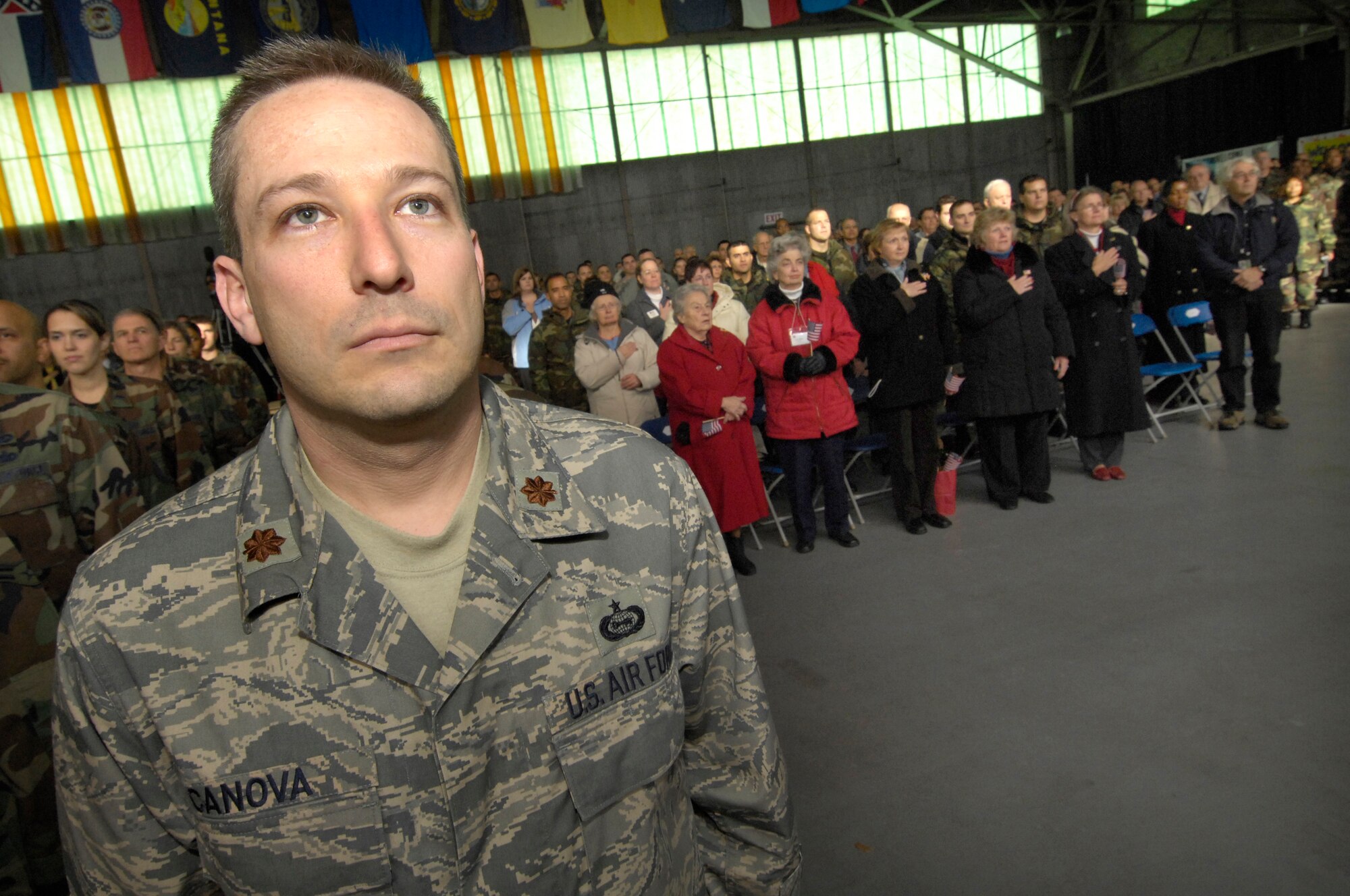 Maj. Alan Canova, a member of the Global Cyberspace Integration Center who works at Hanscom, stands at attention as the U.S. Air Force Band of Liberty performs the National Anthem, kicking off yesterday’s Heroes Homecoming celebration in the Aero Club.  The event officially welcomed home Hanscom-based deployers who have returned from overseas assignments during the past six months, and featured participation from a number of businesses, community organizations and local sports teams. (U.S. Air Force photo by Mark Wyatt.)