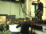 MINOT AIR FORCE BASE, N.D. -- Airman Kyle Andrews, 91st Missile Maintenance Squadron, lowers a missile guidance set off a payload transporter as other team members steady the load. The last NS-20 missile guidance set  was removed and replaced by a newer guidance replacement program (GRP) NS-50 MGS Dec. 4. The GRP primary modification provides the warfighter updated guidance electronics without degrading Minuteman III accuracy. This upgrade replaced the guidance computer and software, while reusing the existing gyro stabilized platform. The upgrades are part of a program to extend the viability of the Minuteman III missiles to 2030. (U.S. Air Force photo by Airman 1st Class Joe Rivera)