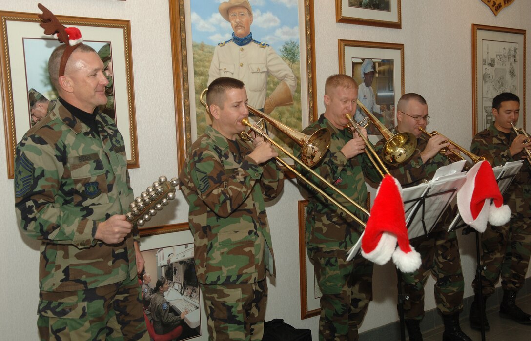 The USAF Heartland of America Band performs Christmas carols at the 91st Space Wing headquarters building at Minot Air Force Base Nov. 30, as Chief Master Sgt. Mark Brejcha (left), 91st SW command chief, gets in the festive spirit. The band performed at various locations across the base. (U.S. Air Force photo by Airman 1st Class Sharida Bishop)
