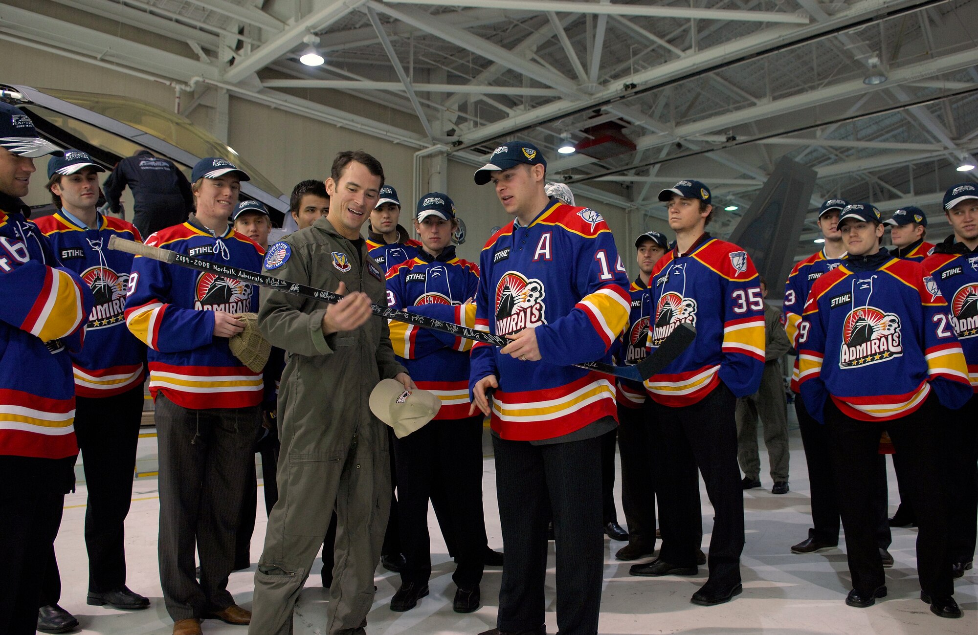 LANGLEY AIR FORCE BASE, Va.--The Norfolk Admirals hockey team presents Maj. Paul "Max" Moga, F-22 Demo Team pilot, with a signed hockey stick after the players visited Langley Dec. 4 and were treated to an F-22 demonstration and tour of the squadron. The Admirals are the top developmental affiliate of the National Hockey League’s Tampa Bay Lightning. (U.S. Air Force photo/Staff Sgt. Samuel Rogers)
