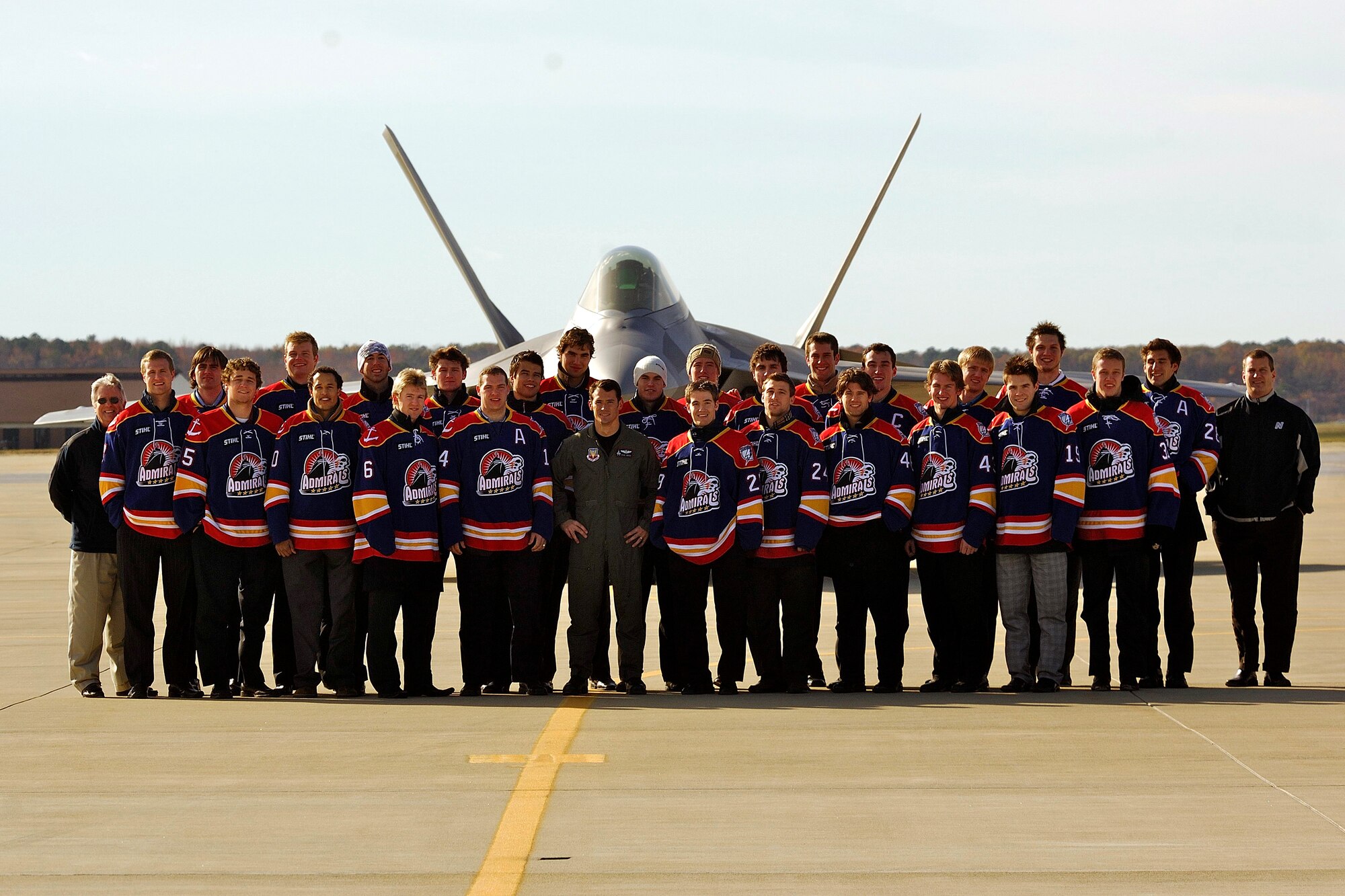 LANGLEY AIR FORCE BASE, Va.--The Norfolk Admirals hockey team poses with Maj. Paul "Max” Moga, F-22 Demo Team pilot, in front of a Raptor here Dec. 4. The Admirals are the top developmental affiliate of the National Hockey League’s Tampa Bay Lightning. (U.S. Air Force photo/Staff Sgt. Samuel Rogers)
