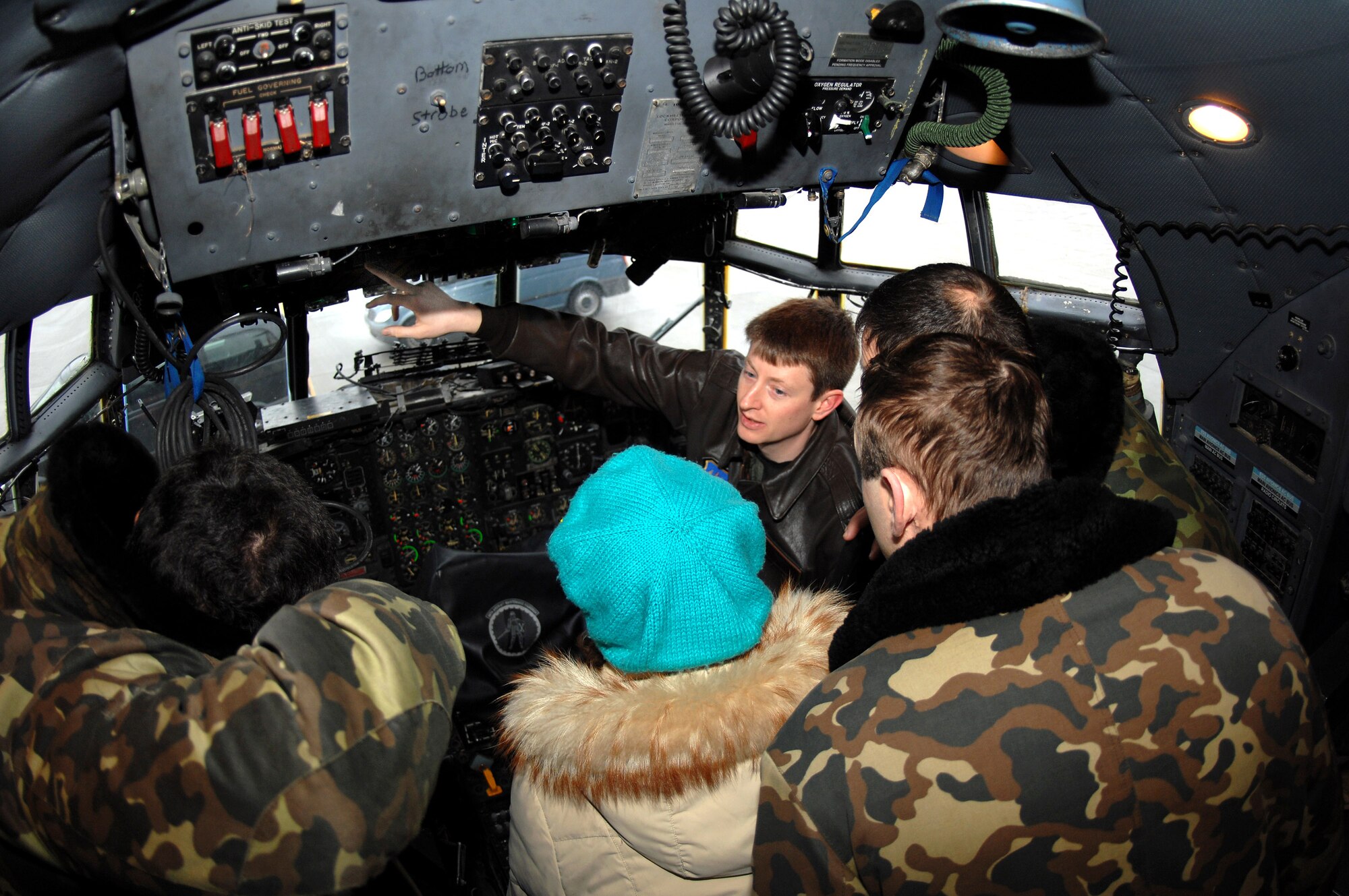 Capt. Chris Dorough explains the C-130 Hercules cockpit to Russian air force officers and their U.S. embassy interpreter Dec 5 at Ramstein Air Base Germany. The Russian air force members visited to plan a United States/Russia exercise demonstrating theater security cooperation among the U.S. Air Forces in Europe and Russian federation air force personnel. Captain Dorough is assigned to the 37th Airlift Squadron. (U.S. Air Force photo/Airman 1st Class Kenny Holston)
