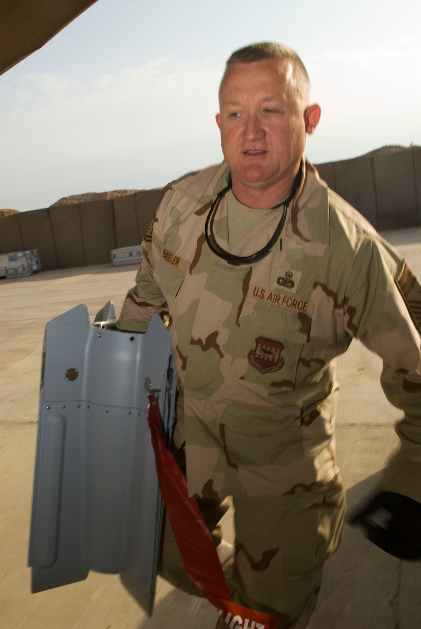 BALAD AIR BASE, Iraq -- Chief Master Sgt. Paul Wheeler, 332nd Air Expeditionary Wing command chief, carries the end of a bomb unit during a morale visit with the Airmen of the 332nd Expeditionary Maintenance Squadon Ammunitions Flight here, Dec. 5. Wing leadership observed and assisted the Airmen with preparing the munitions. Chief Wheeler is deployed from Dyess Air Force Base, Texas. (U.S. Air Force photo/Staff Sgt. Joshua Garcia)