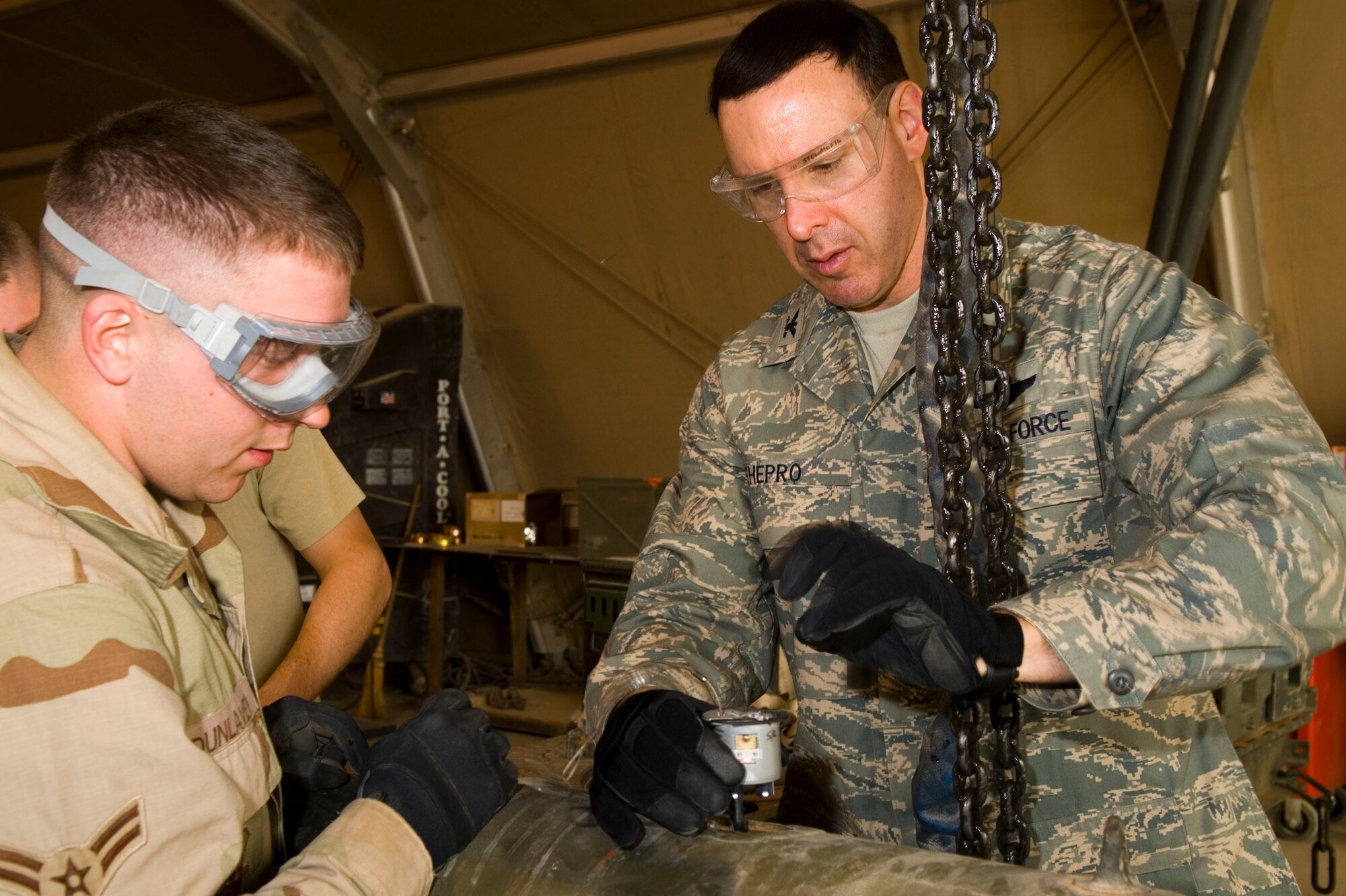 BALAD AIR BASE, Iraq -- Airman 1st Class Joseph Dunlavey, 332nd Expeditionary Maintenance Squadron, shows Col. Steven Shepro, 332nd Air Expeditionary Wing vice commander, the proper way to connect the fuse initiator to the fuse of a bomb unit during a bomb build here, Dec. 5. Airman Dunlavey is deployed from Spangdahlem Air Base, Germany and Colonel Shepro is deployed from Pope Air Force Base, N.C. (U.S. Air Force photo/Staff Sgt. Joshua Garcia)