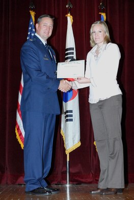 OSAN AIR BASE, South Korea – Col.  Jon A. Norman, 51st Fighter Wing commander, congratulates Mrs. Ashley Jones, 51st Mission Support Squadron, for her selection as the Air Force Education and Training Manager of the Year (Cat II-D). (U.S. Air Force photo by Tech. Sgt. Scott A Labuda)
