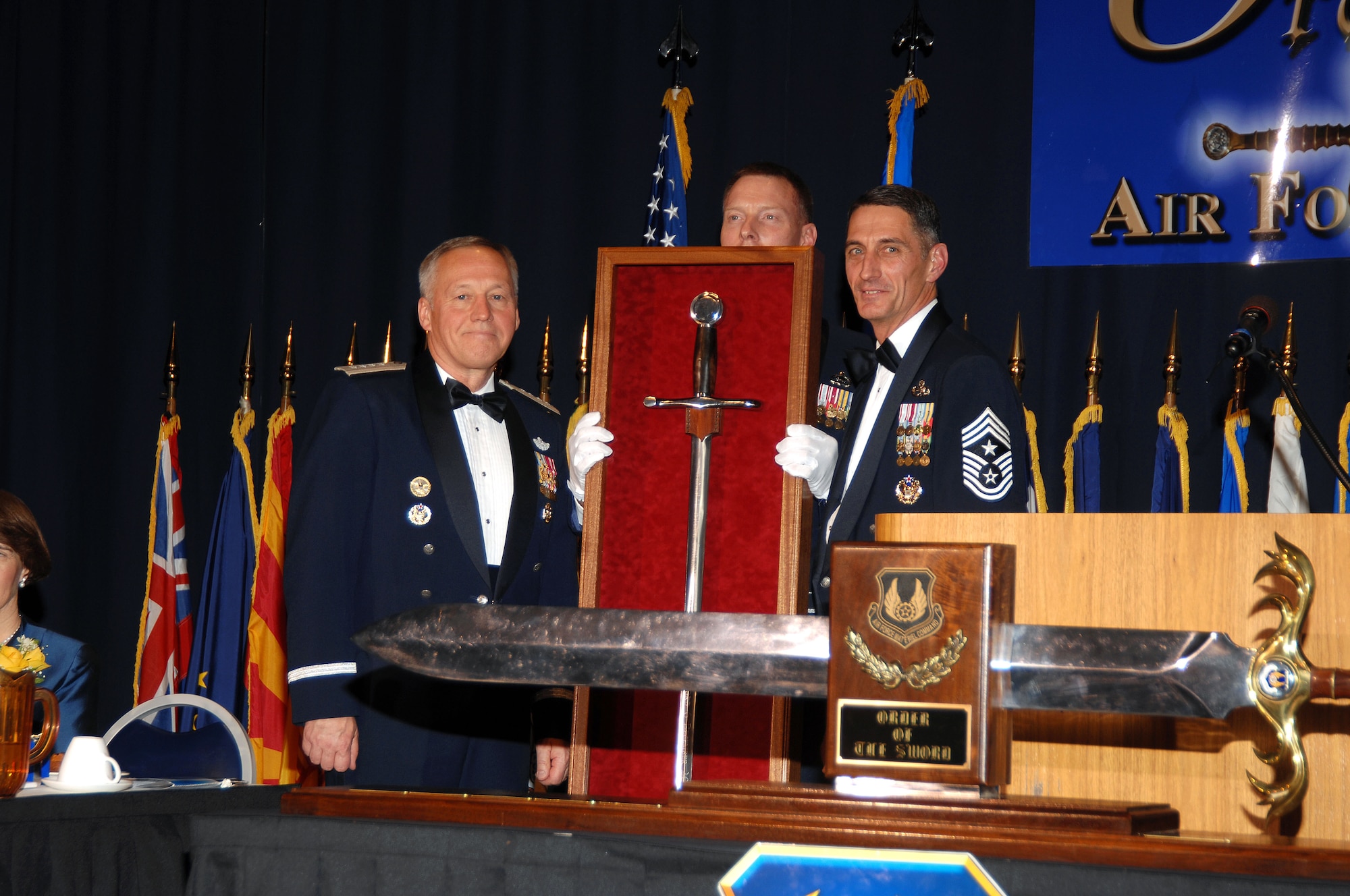 With the Air Force Materiel Command Order of the Sword in the foreground, Gen. Bruce Carlson, AFMC commander (left), is joined by the Order of the Sword sergeant at Arms, Chief Master Sgt. William Gurney, who holds General Carlson’s personal sword, and Chief Master Sgt. Jonathan Hake, AFMC command chief master sergeant. (Air Force photo by Ben Strasser)
