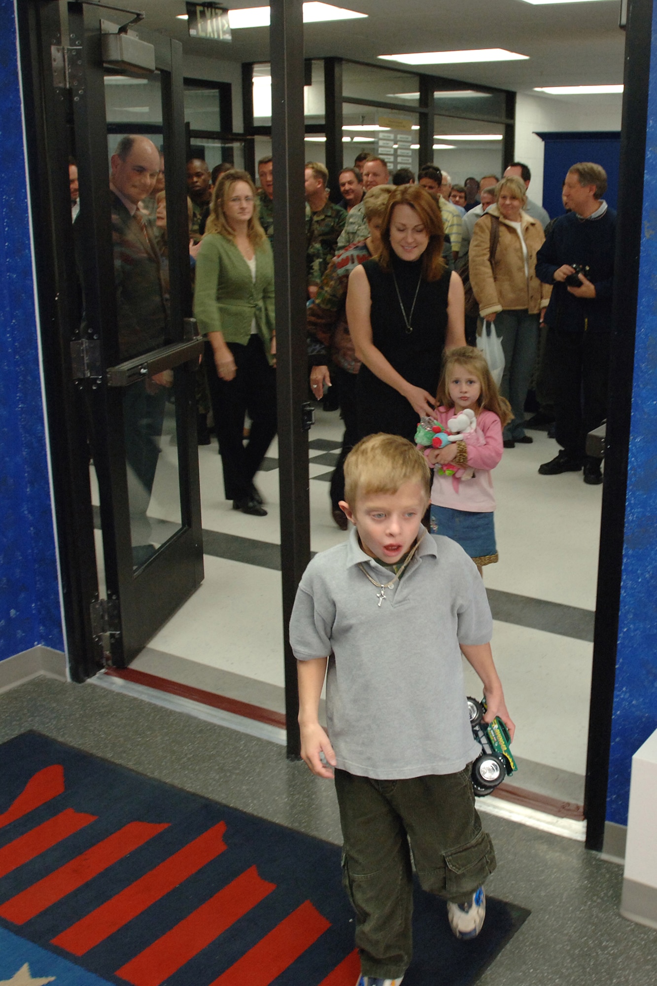 Ben Roessler is among the first to enter the newly dedicated Raymond E. Roessler Team Center in Bldg. 507. Following behind are his mother, Annette Roessler, and sister Abby, and other members of the Roessler family. The center, which includes a cafeteria and meeting area, is named for Lt. Col. Raymond Roessler, former 309th Commodities Maintenance Group deputy director, who died in October in an aircraft accident. 