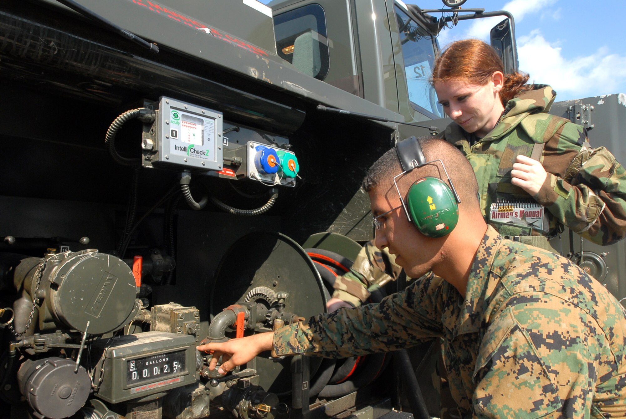Marine Lance Cpl. Joseph Rivera and Airman 1st Class Christina Flake look at the fuel gauge of a R-11 fuel truck Dec. 6 at Kadena Air Base, Japan, as part of the maintenence process to ensure the fuel truck is operating correctly. Airmen from the 18th Wing joined with elements from the 1st Marine Aircraft Wing to conduct a joint operational readiness exercise Dec. 3 to 7. Corporal Rivera is with the Marine Air Group 12 and Airman Flake is with the 18th Logistic Readiness Squadron. (U.S. Air Force photo/Senior Airman Darnell T. Cannady)  
