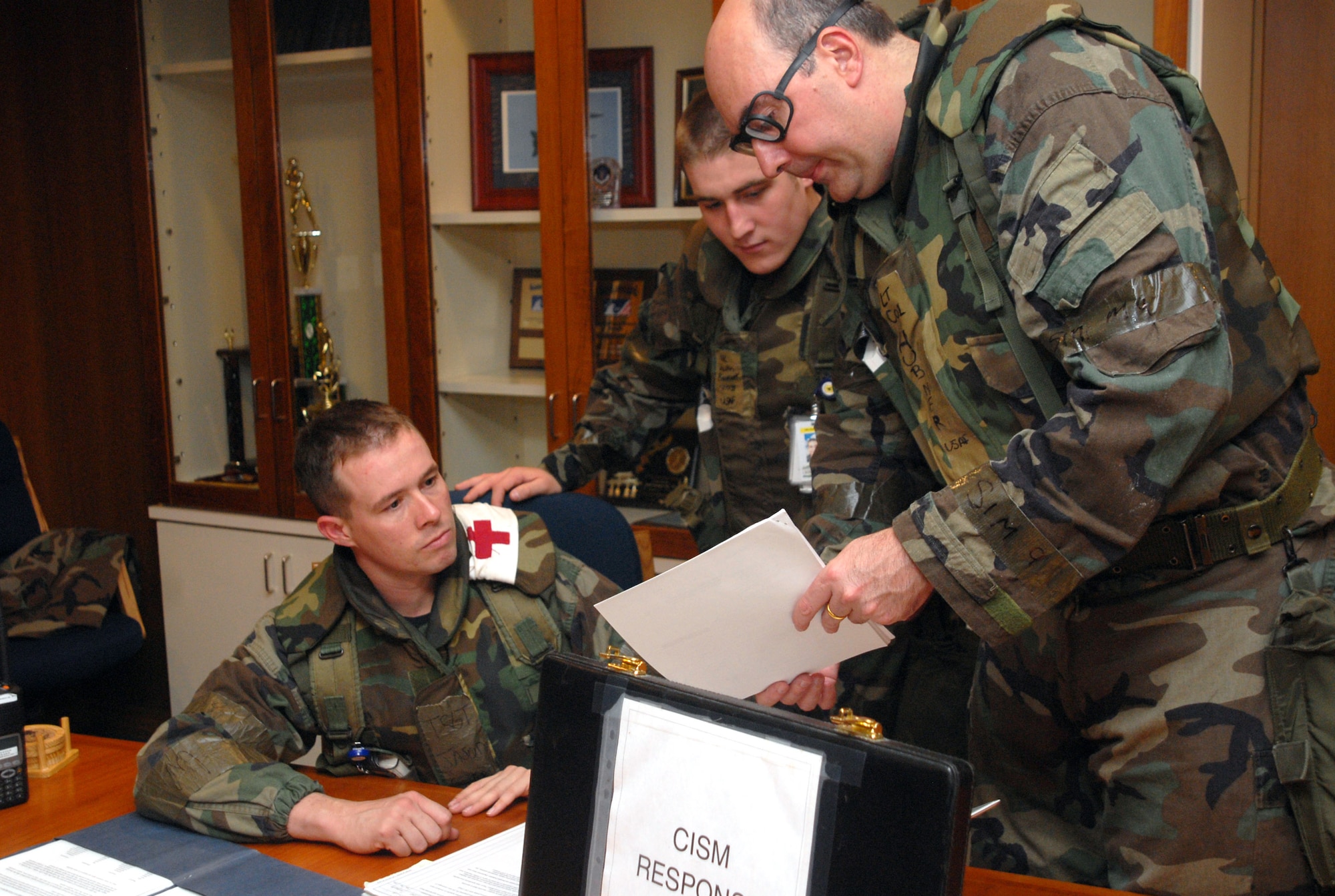 Tech. Sgt. Jason Sharp, Airman 1st Class Justin Beckett and Lt. Col. Mark Hubner review mental health procedures to use in response to scenarios during a joint operational readiness exercise Dec. 3 to 7 at Kadena Air Base, Japan. The scenarios enable base agencies to work together to mitigate real-world situations and heighten readiness capabilities. The Airmen are all members of the 18th Medical Operations Squadron. (U.S. Air Force photo/Staff Sgt. Christopher Marasky)