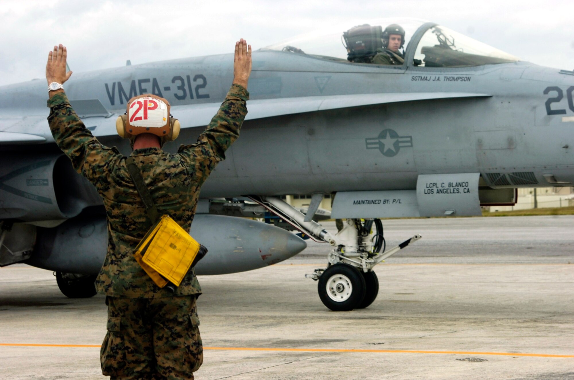 Marine Cpl. Sterling Robertson instructs pilot Capt. Olgierd Weiss with take off commands  Dec. 4 at Kadena Air Base, Japan. Corporal Robertson is a powerliner for Marine Fighter Attack Squadron 212. A powerliner's job is to instruct the pilot on start up and launch out the pilot. (U.S. Marine Corps photo/Lance Cpl. Jacqueline Diaz) 