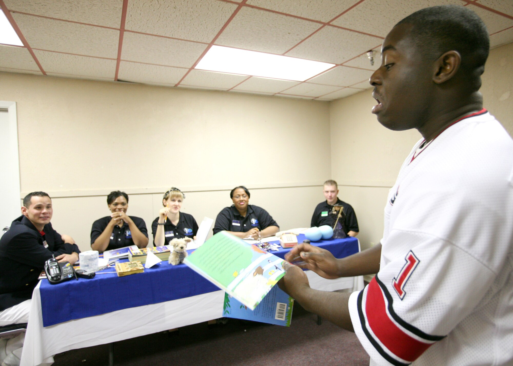 In a Bill Cosby impression, Senor Airman Jonathan Allen reads from a children's book to a panel during the Air Force World Wide Talent Contest at Lackland Air Force Base, Texas. Airman Allen, from F. E. Warren Air Force Base, Wyo., is a trumpet player and is competing for a spot on the 2008 Tops in Blue team. The competition, held Dec. 2-10, is the first step to Tops in Blue.  (U.S. Air Force photo/Robbin Cresswell)