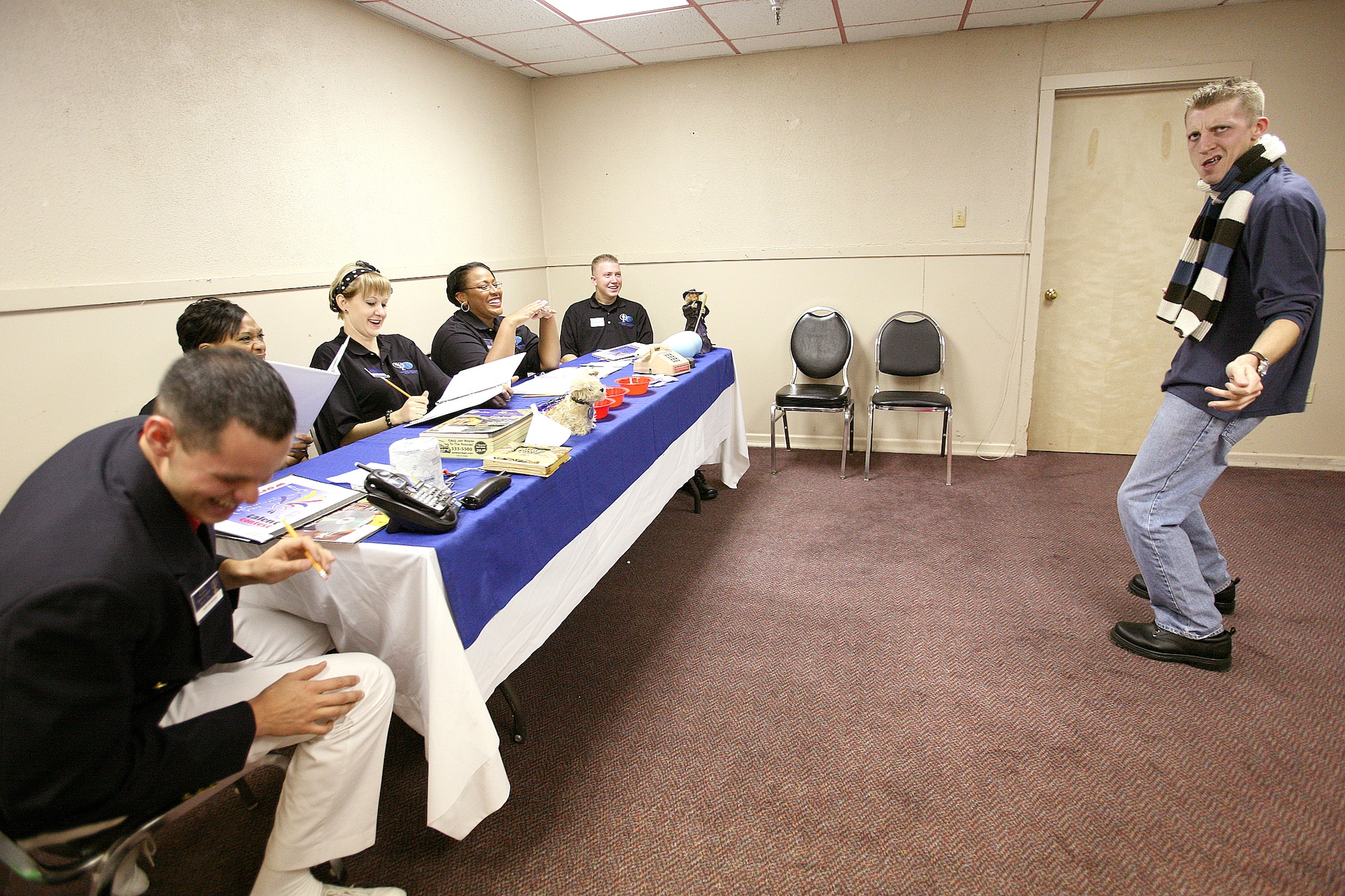 Airman 1st Class Brian Carmack solicits a laugh from a panel of judges during a comedy routine in the "specialty" audition during the Air Force World Wide Talent Contest held at Lackland Air Force Base, Texas, from December 2-10. The five-person panel of current and former Tops in Blue judges are (from left) Staff Sgt. Daniel Rutherford, Fort Meade, Maryland; Staff Sgt. LaTanza Meabon-Whiteside, Little Rock AFB, Ark.; Staff Sgt. Amber Young, Offutt AFB, Neb.; Staff Sgt. Tatenisia Stirrup, Tinker AFB, Okla.; and Senior Airman Bryce Zabric, Dyess AFB, Texas. World Wide is the first step to Tops in Blue.  Airman Carmack, a dental assistant at Lackland AFB, is competing for male vocalist for the 2008 Tops in Blue show.  (U.S. Air Force photo/Robbin Cresswell)