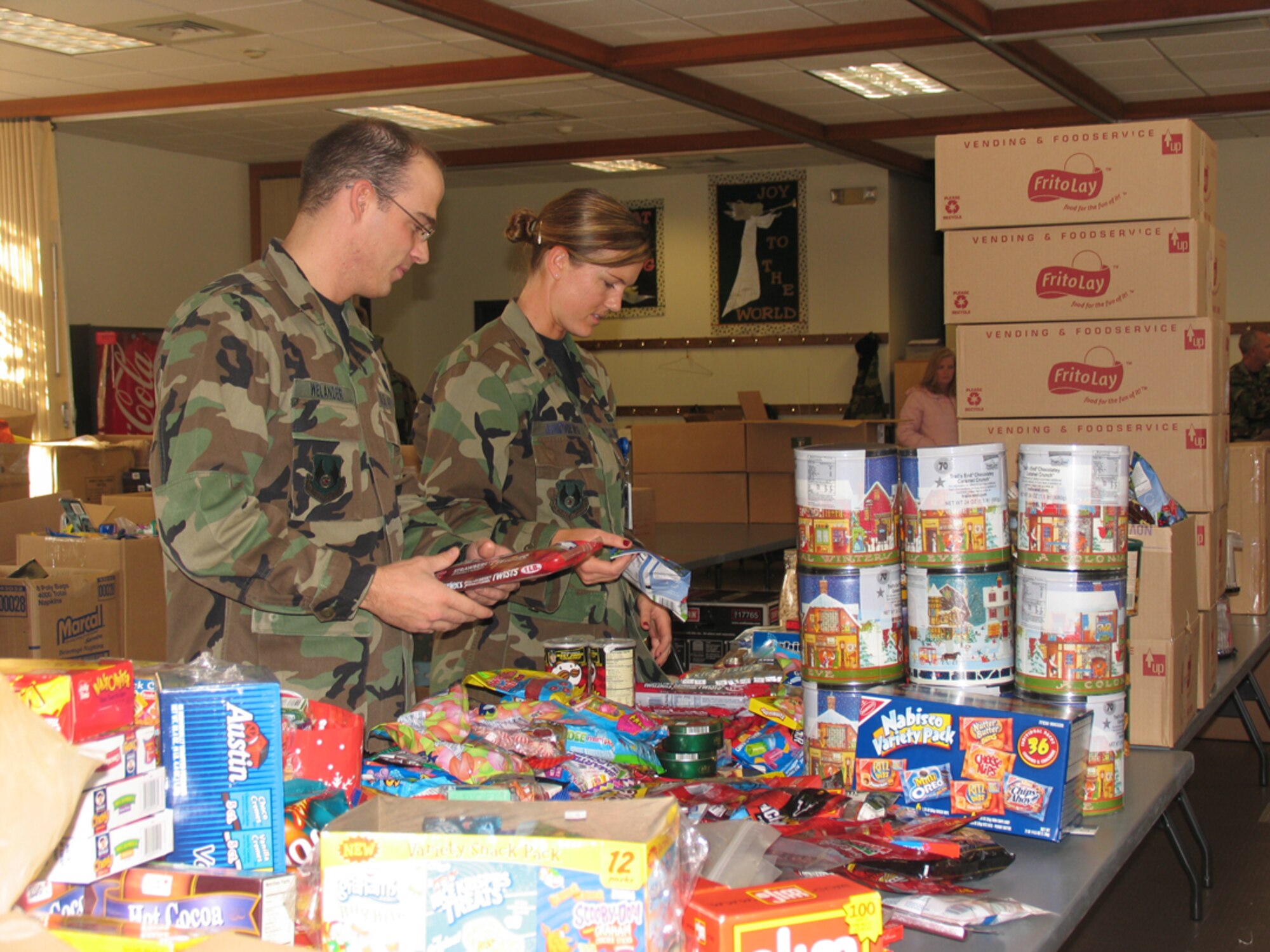 HANSCOM AFB, Mass. – 642nd Electronic Systems Squadron 1st Lts. Trent Welander and Jamie Andrews assemble troop care packages on Dec. 6 at the Base Chapel Annex. The troop care package drive was sponsored by the Company Grade Officers’ Council. Volunteers from all over the base supported the effort. More than 1000 care packages were assembled and shipped to troops supporting the Global War on Terror in the Area of Responsibility. (U.S. Air Force photo by Rhonda Siciliano)