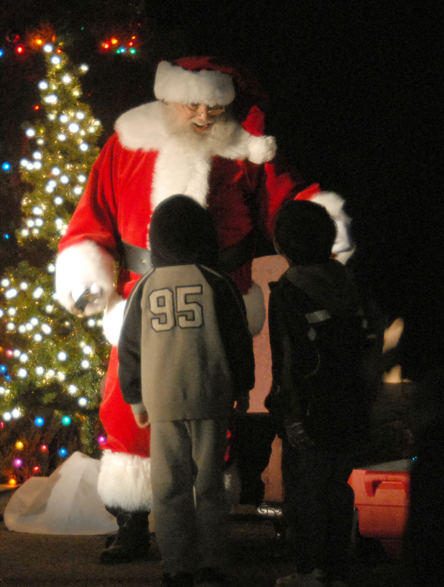 Santa Claus greets Edwards' children during the Christmas tree lighting ceremony at the Base Exchange parking lot here Dec. 5. (Photo by Senior Airman Julius Delos Reyes)