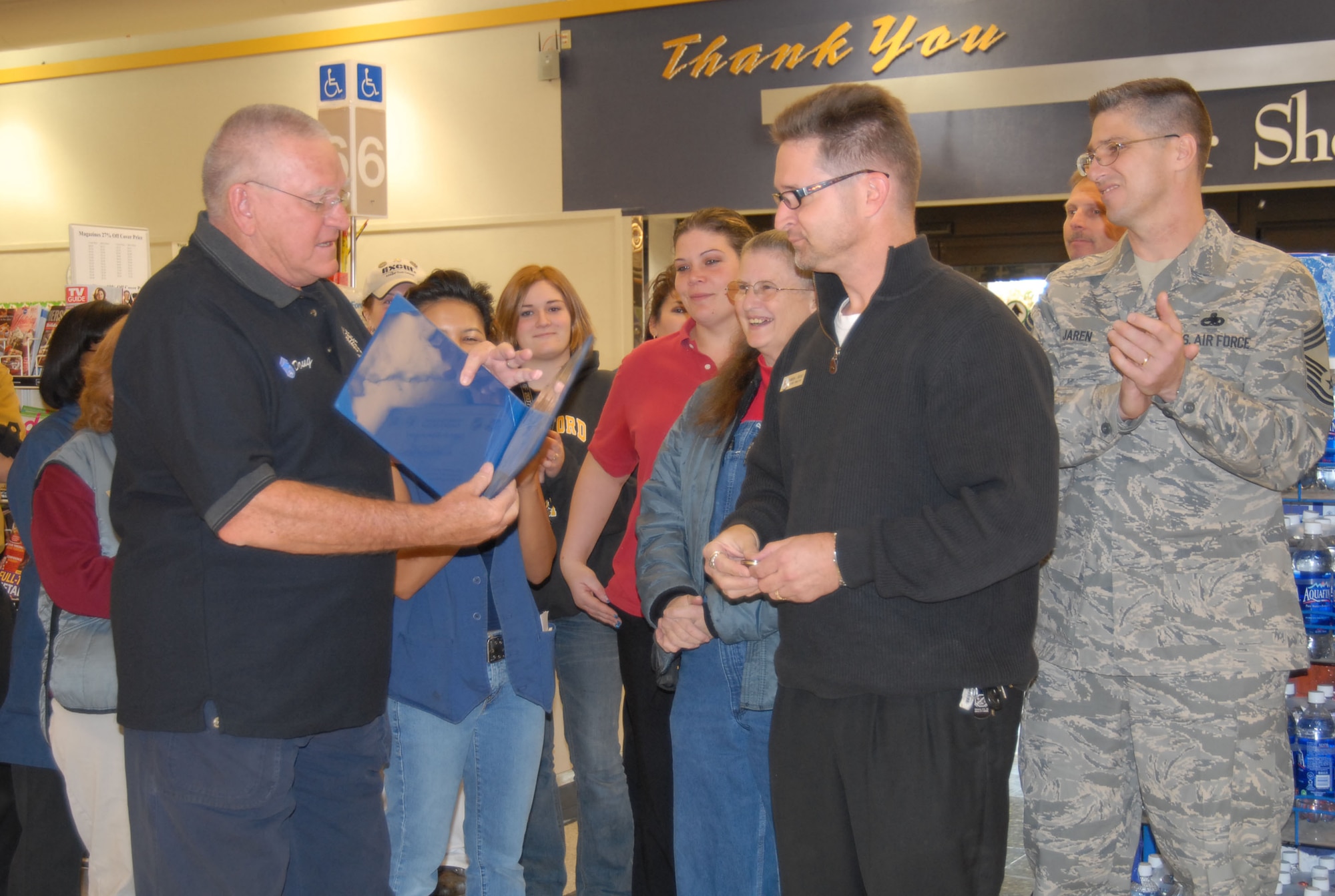 Doug Nelson (left), former Air Force Flight Test Center Museum director, gives the Dare to Soar award to Andrew Brooks, the Edwards Commissary director. Mr. Brooks received the award on behalf of the whole Commissary staff. The Dare to Soar award is presented by the Chief's Group for outstanding performance. (Photo by Senior Airman Julius Delos Reyes)