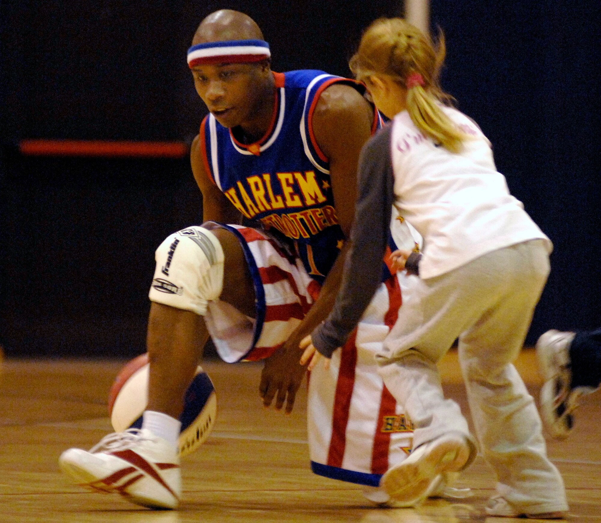 Harlem Globetrotter "Sweet Pea" tries to keep the basketball away from audience member Cailynn Smith during a basketball game Dec.1at the Dragon Fitness Center at Aviano Air Base, Italy . The Harlem Globetrotters are touring Army and Air Force installations throughout Europe as part of their "Magic As Ever" 2008 world tour. (US Air Force photo/Airman 1st Class Ashley Wood) 