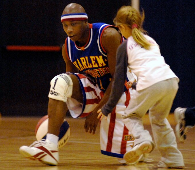 Harlem Globetrotter "Sweet Pea" tries to keep the basketball away from audience member Cailynn Smith during a basketball game Dec.1at the Dragon Fitness Center at Aviano Air Base, Italy . The Harlem Globetrotters are touring Army and Air Force installations throughout Europe as part of their "Magic As Ever" 2008 world tour. (US Air Force photo/Airman 1st Class Ashley Wood) 