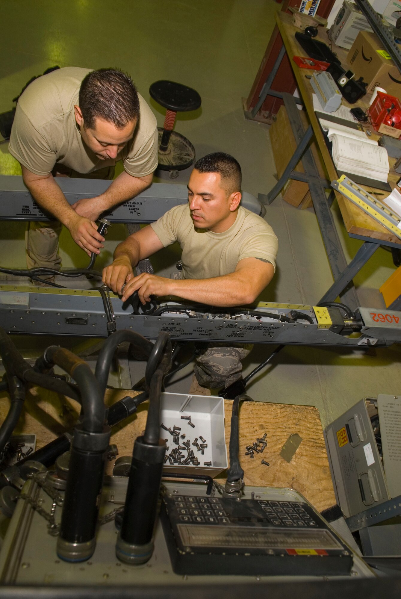 BALAD AIR BASE, Iraq -- Tech. Sgt. Patrick Southard, and Tech. Sgt. Marco Arredondo, both maintainers from the 332nd Expeditionary Maintenance Squadron, connect an F-16 Fighting Falcon missile launcher to a testing device here, Dec. 7. The tester is able to troubleshoot different portions of the missile launcher to identify any deficient parts. Sergeant Southard is deployed from Spangdahlem Air Base, Germany, and Sergeant Arredondo is deployed from the Indiana Air National Guard. (U.S. Air Force photo/Staff Sgt. Joshua Garcia)