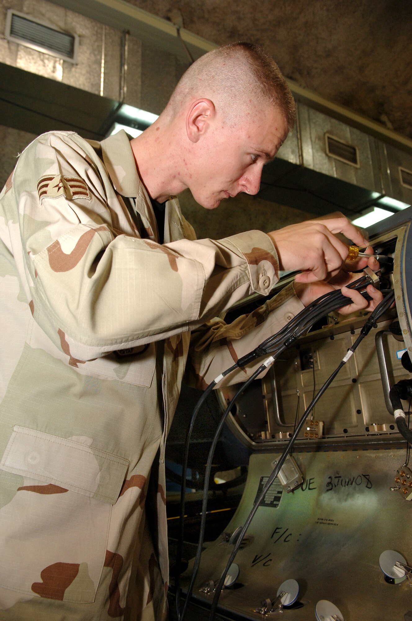 SOUTHWEST ASIA - Senior Airman Gregory Huffman, 379th Expeditionary Maintenance Squadron, repairs the F-15E data-link pod recently at a Southwest Asia air base. Airman Huffman is deployed from Seymour Johnson AFB, N.C. (U.S. Air Force photo/Master Sgt. Greg Kunkle)